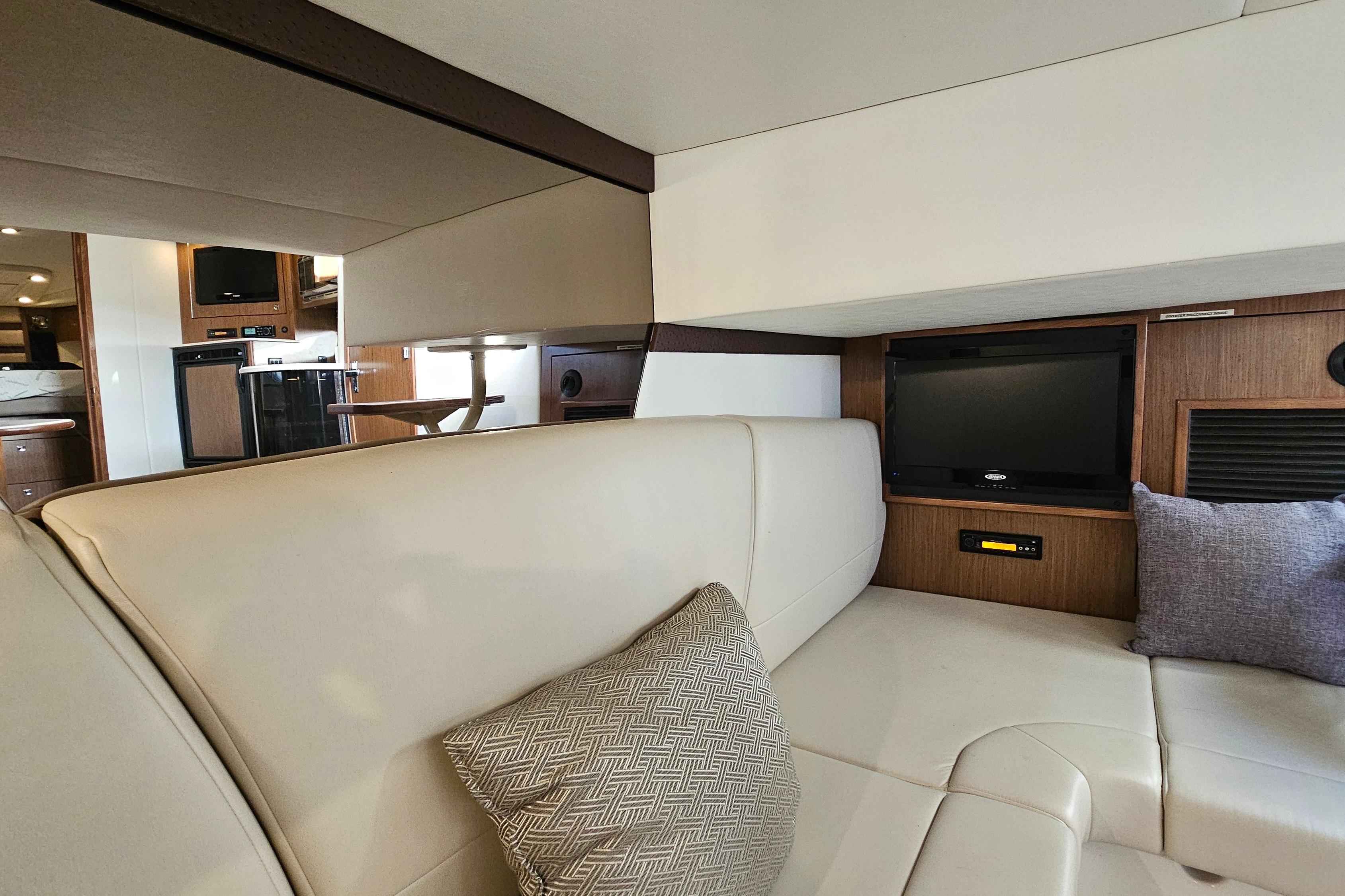 Interior of 2017 Cruisers Yachts 380 Express with leather seating and built-in TV.