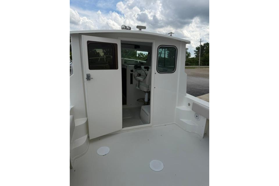 2016 Parker 2520 Sport Cabin boat interior with open cabin door under cloudy sky.