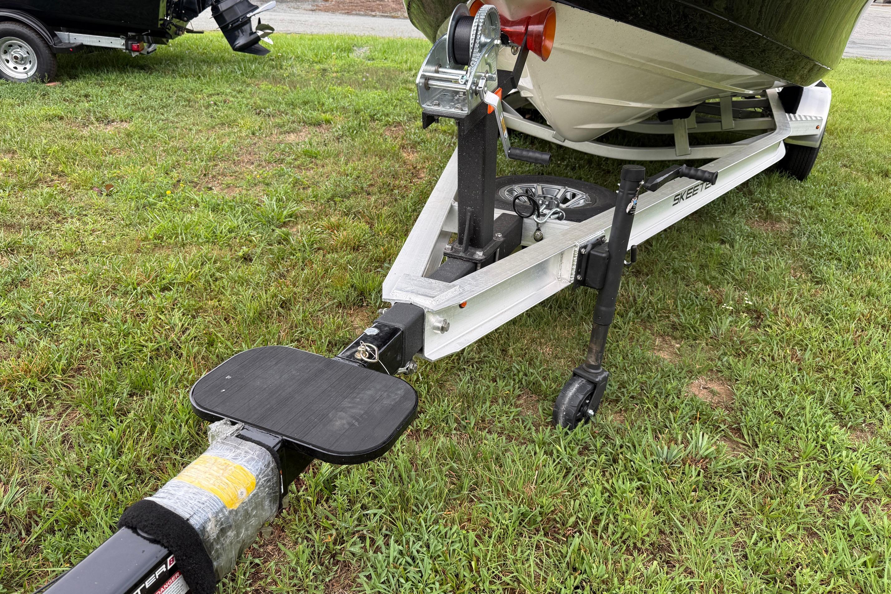 2026 Skeeter SX2350 boat trailer on grass, showcasing hitch and wheel assembly.