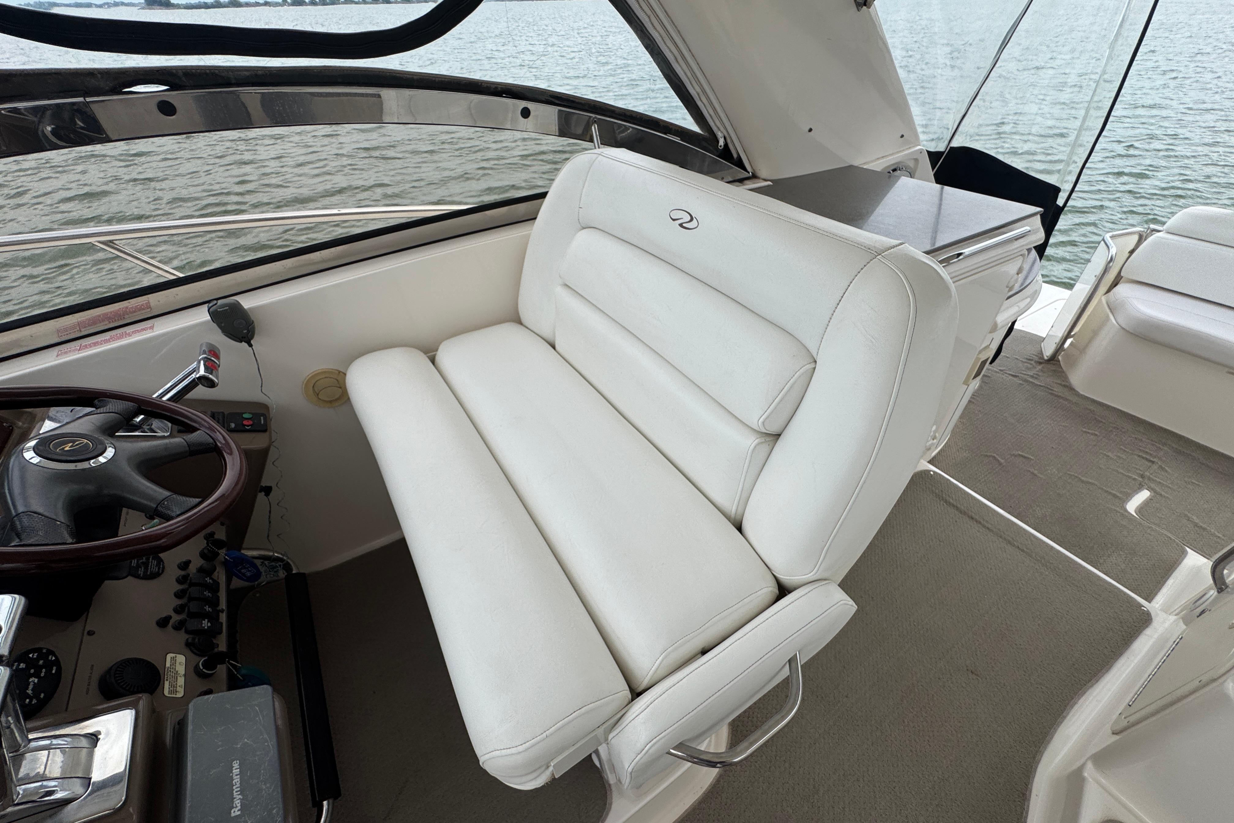 2005 Regal Commodore 4260 boat interior with white leather seating and steering wheel.