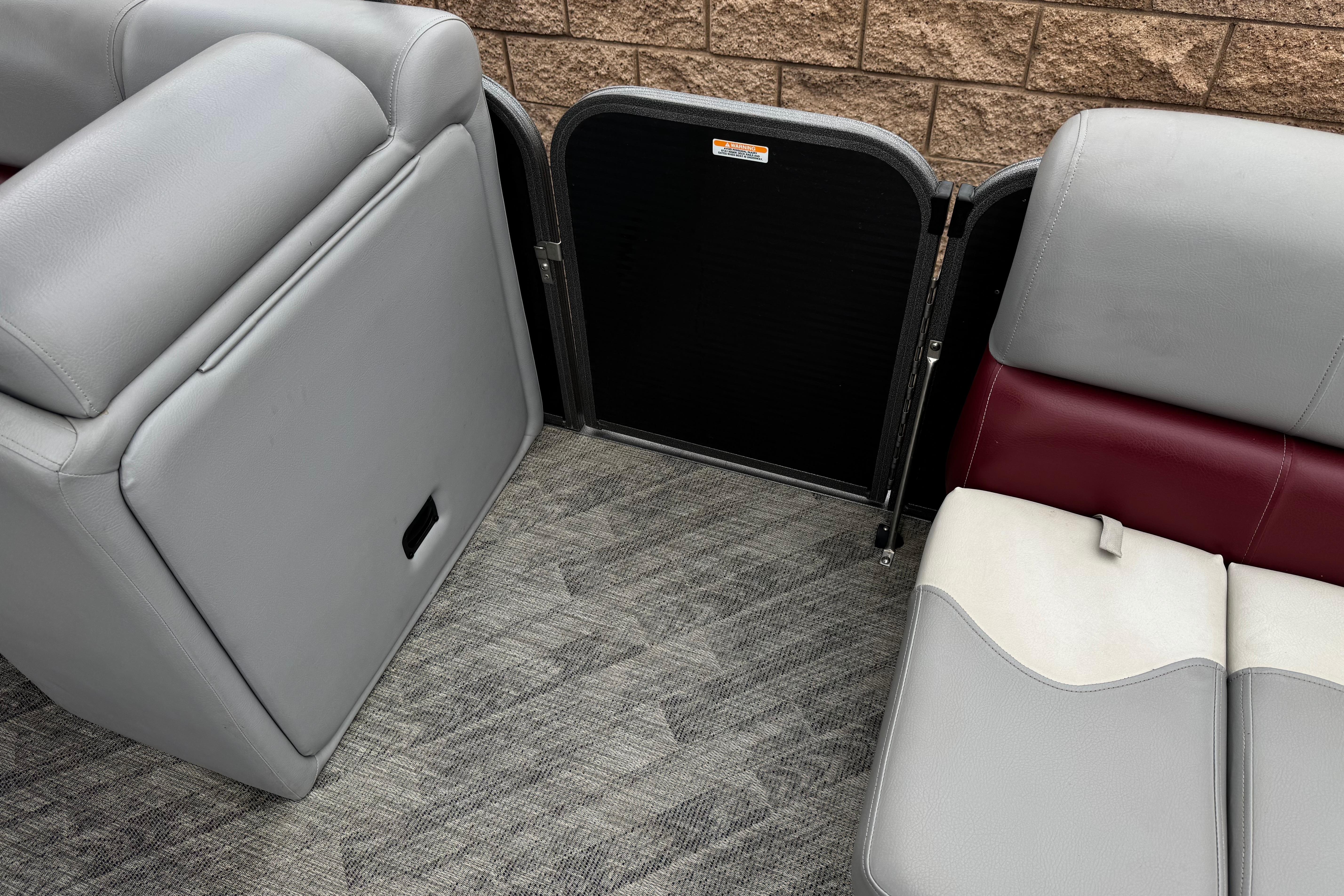 Interior seating of 2020 Manitou 18 Aurora LE pontoon boat with gray and maroon upholstery.