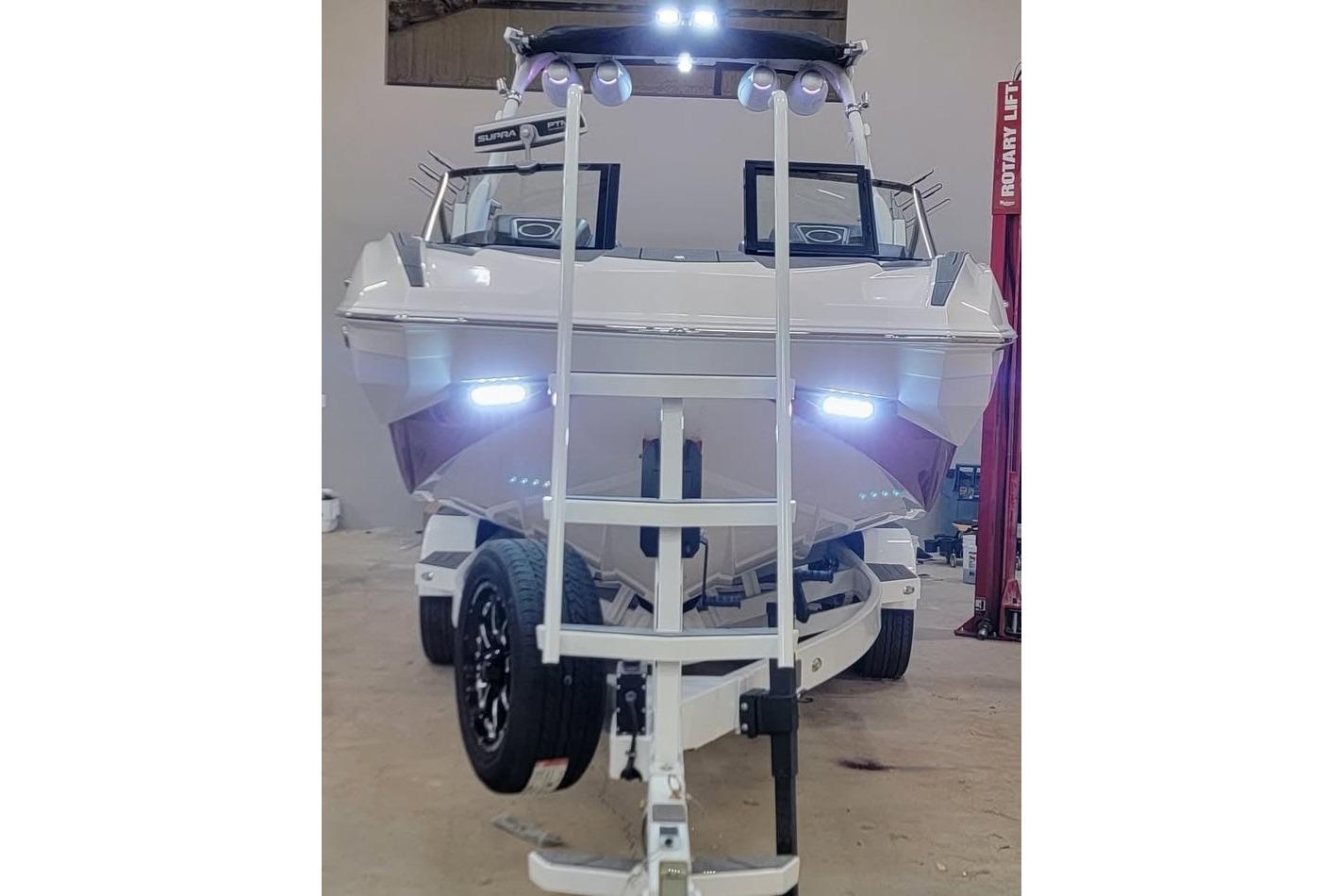 2023 Supra SE 550 boat on trailer, front view with bright LED lights.