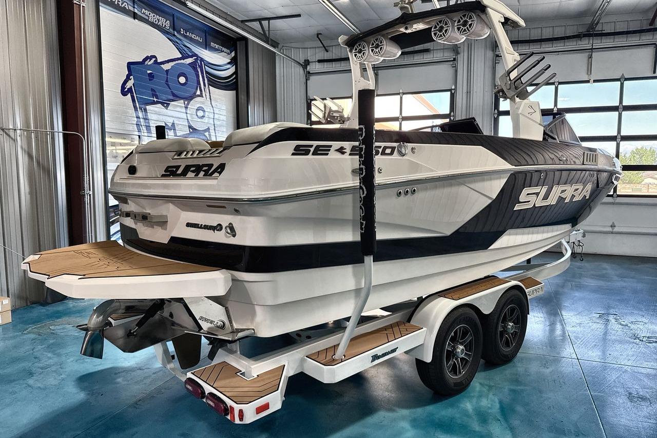2020 Supra SE boat on trailer in showroom, featuring sleek design and modern features.