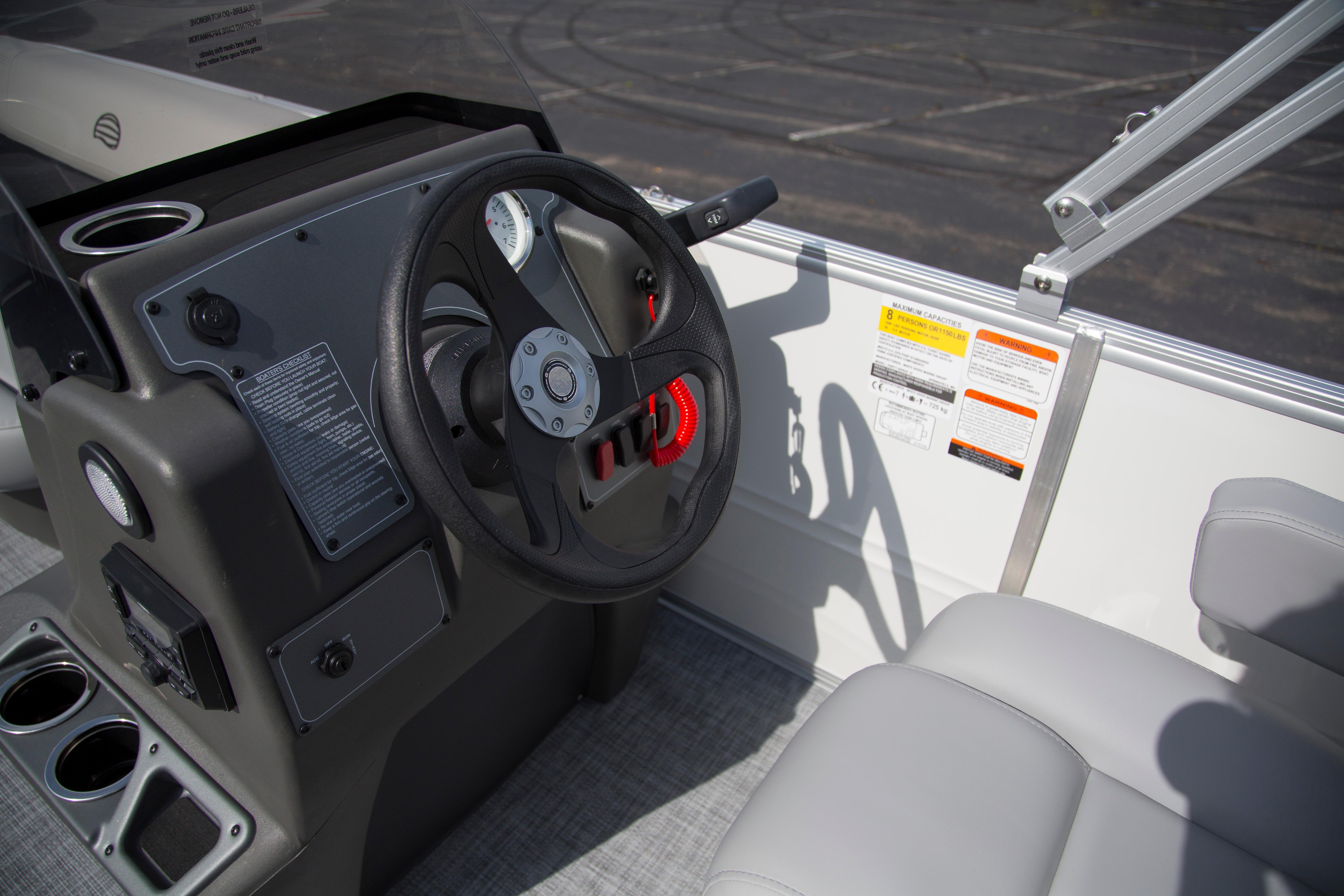 2026 Sun Tracker Party Barge 16 DLX steering console with gauges and controls.