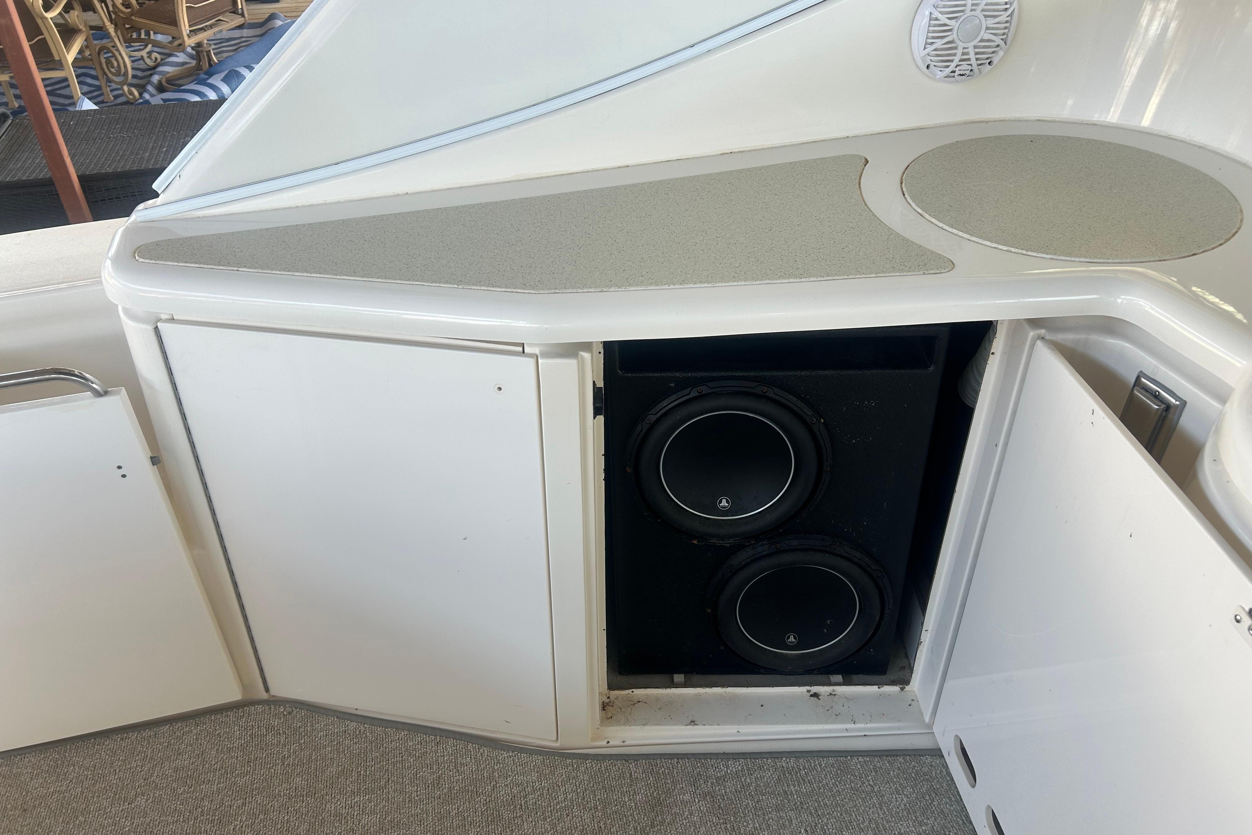 1997 Cruisers 4270 boat with open cabinet revealing dual subwoofers.