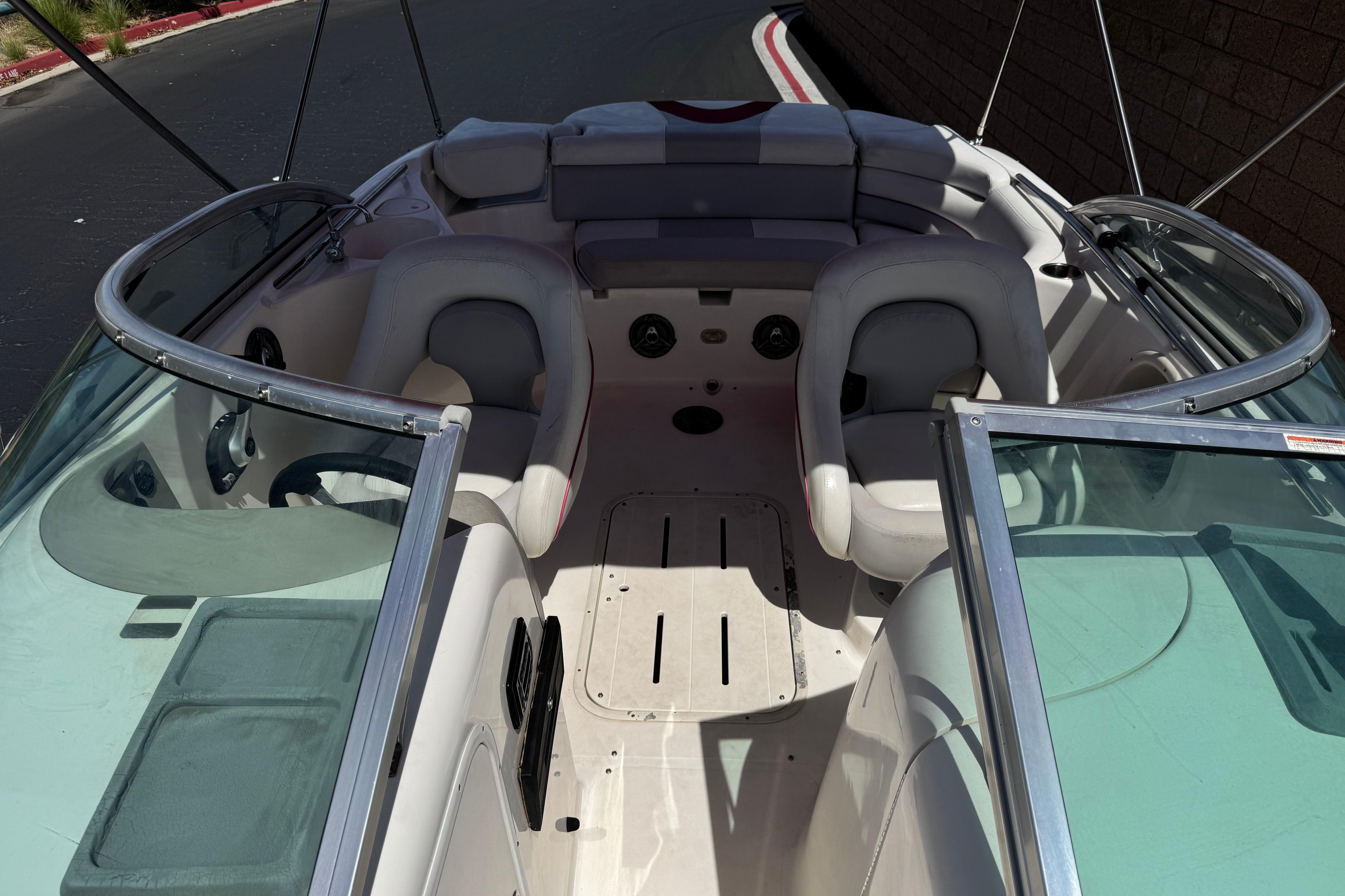 2010 Bryant 255 boat interior with seating and steering wheel, showcasing sleek design.