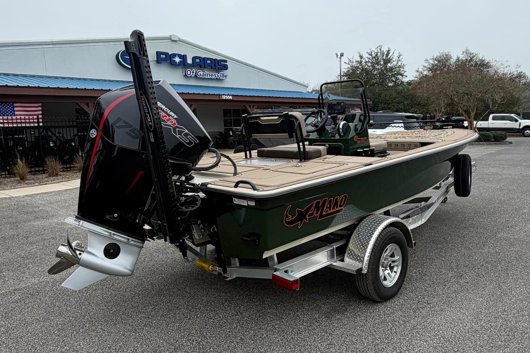 2025 Mako 18 Pro Skiff Backwater Edition boat on trailer, parked outside dealership.