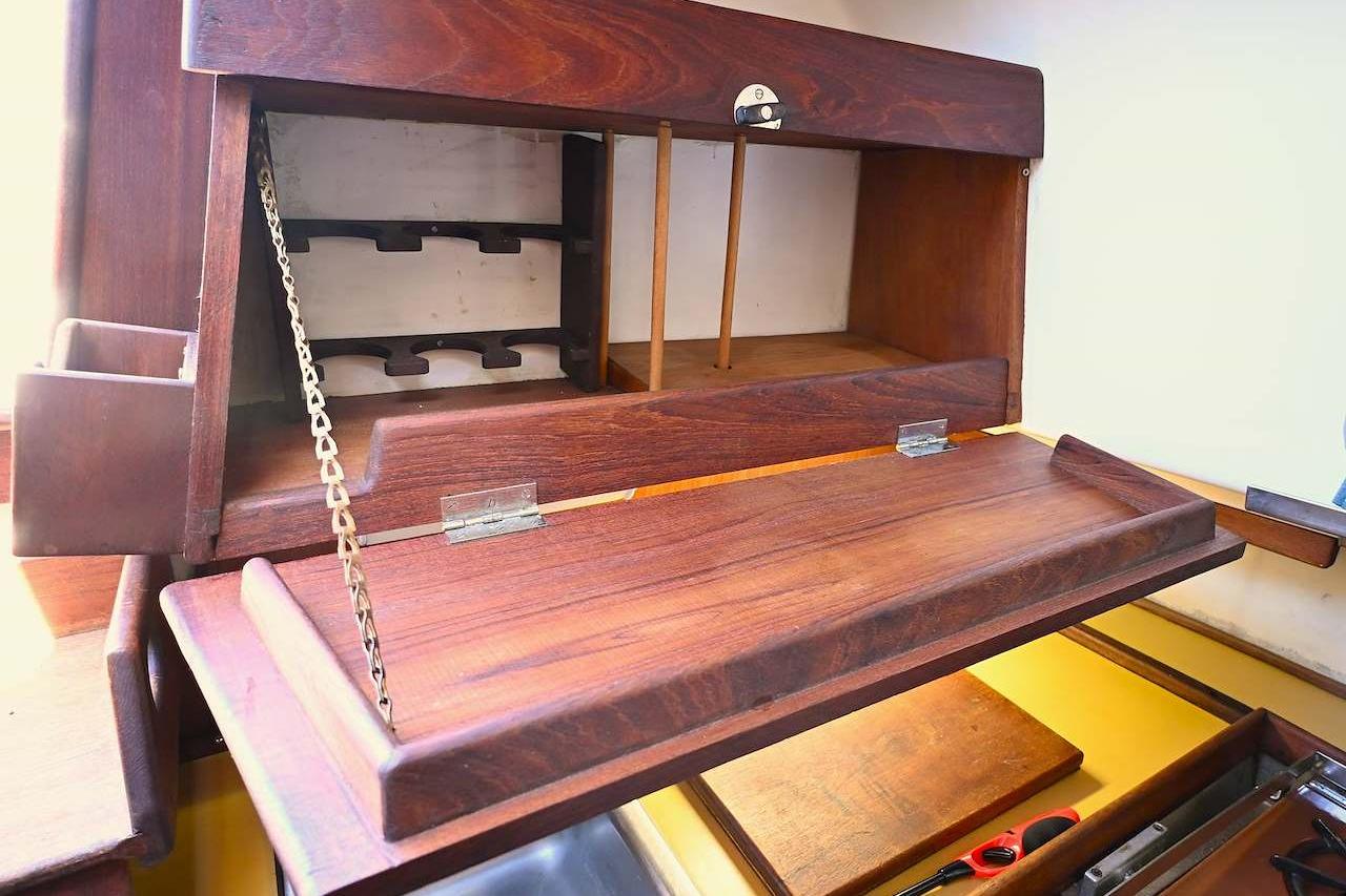 Wooden interior cabinet of 1977 Mercator Offshore boat, featuring fold-down desk and storage.