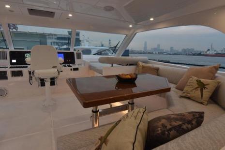 Luxurious 2022 Horizon PC65 yacht interior with plush seating and elegant table.