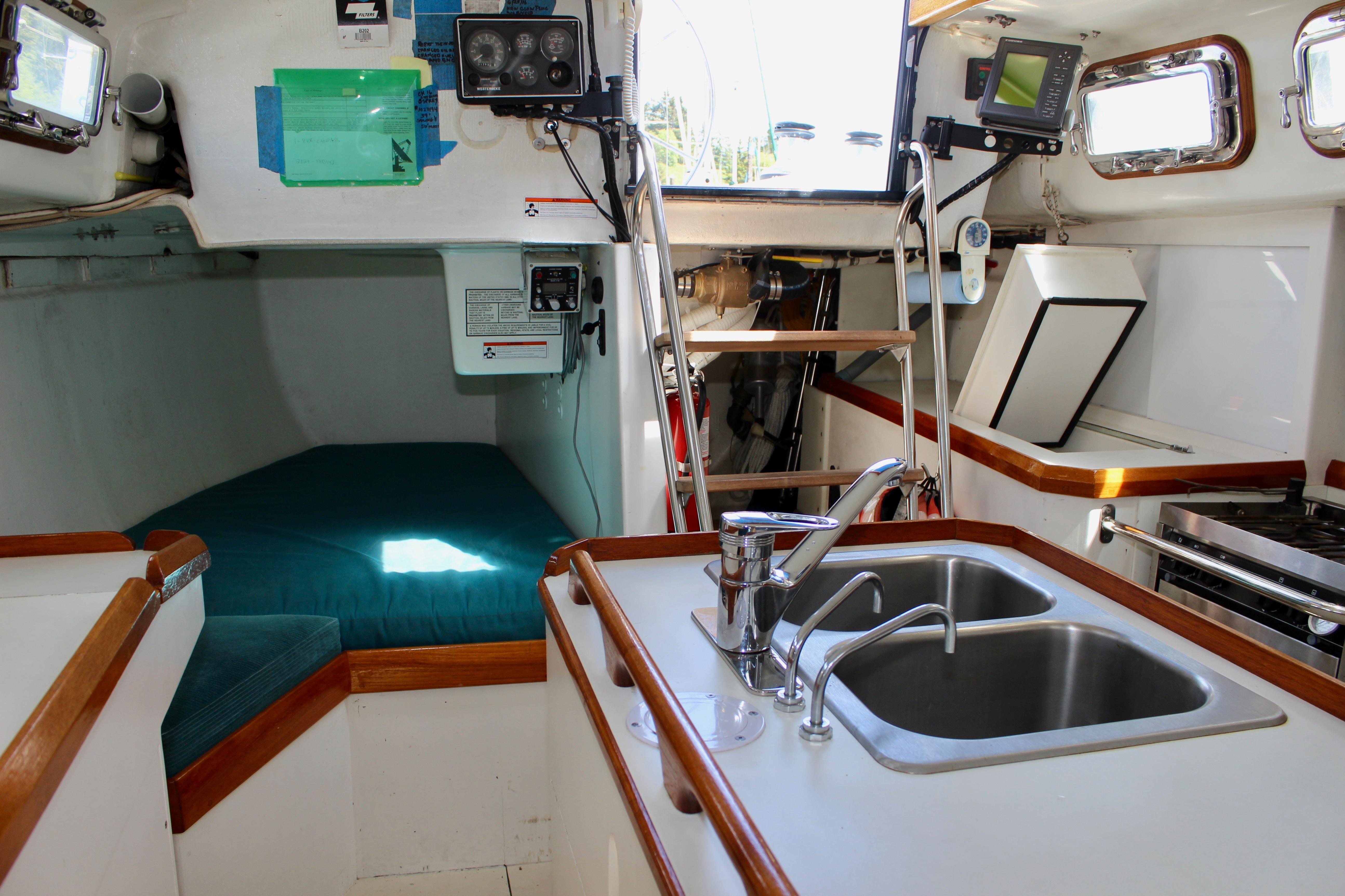 Interior of a 1993 Freya 39 sailboat featuring a compact kitchen and sleeping area.