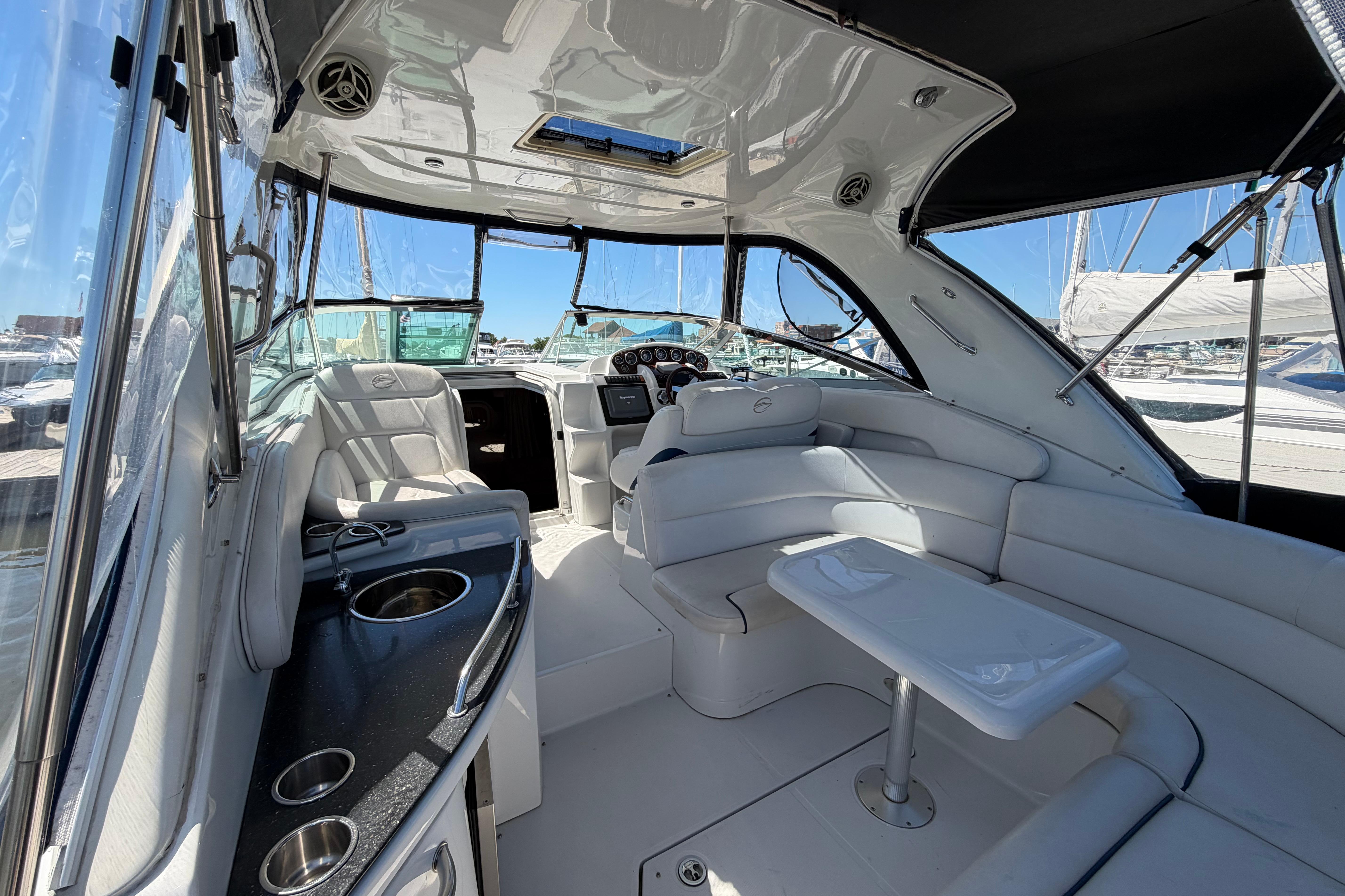 2008 Crownline 340 CR yacht interior with white seating, table, and helm station.