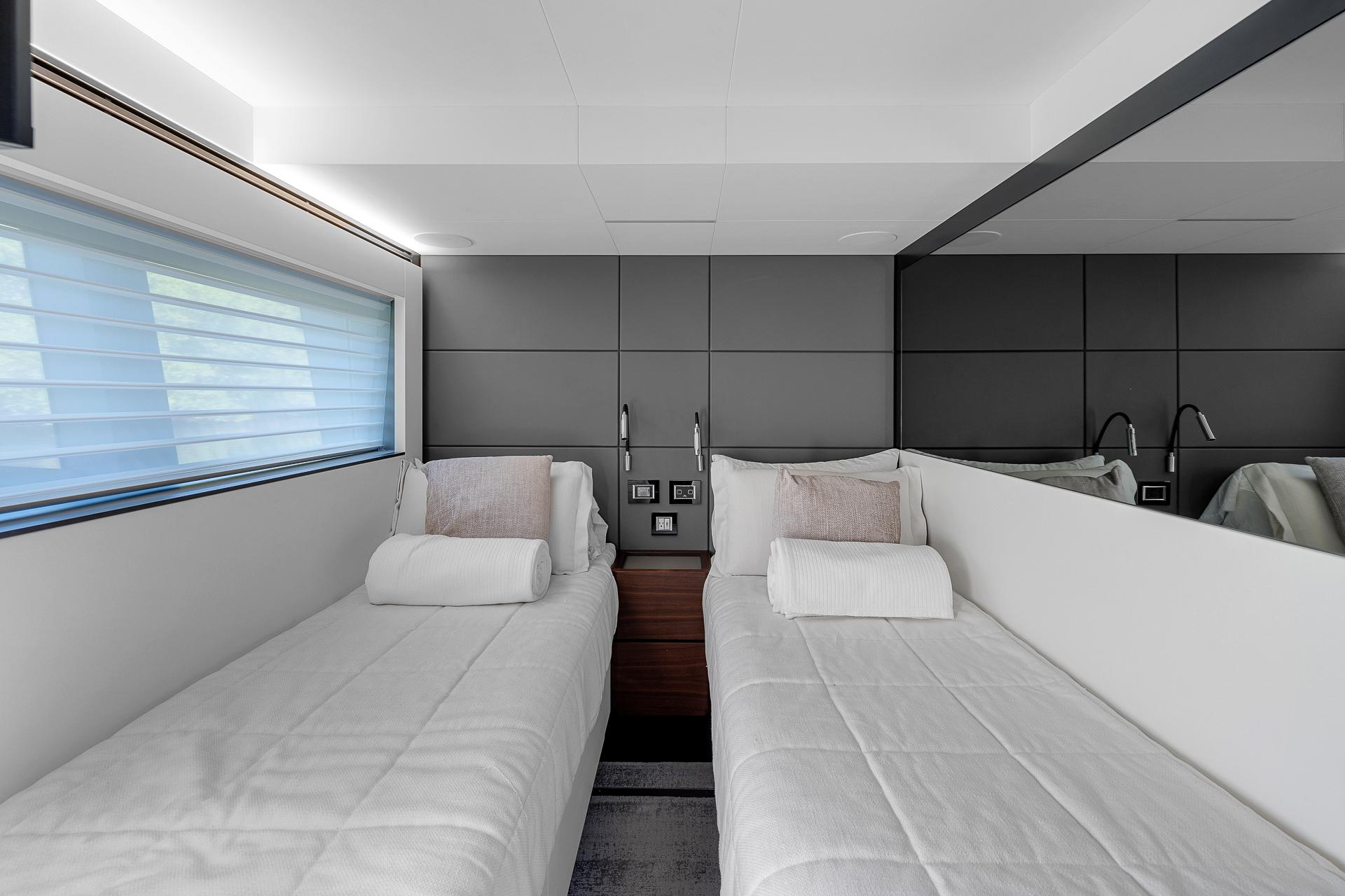 Luxurious twin cabin in 2022 Astondoa 66 yacht with modern design and plush bedding.