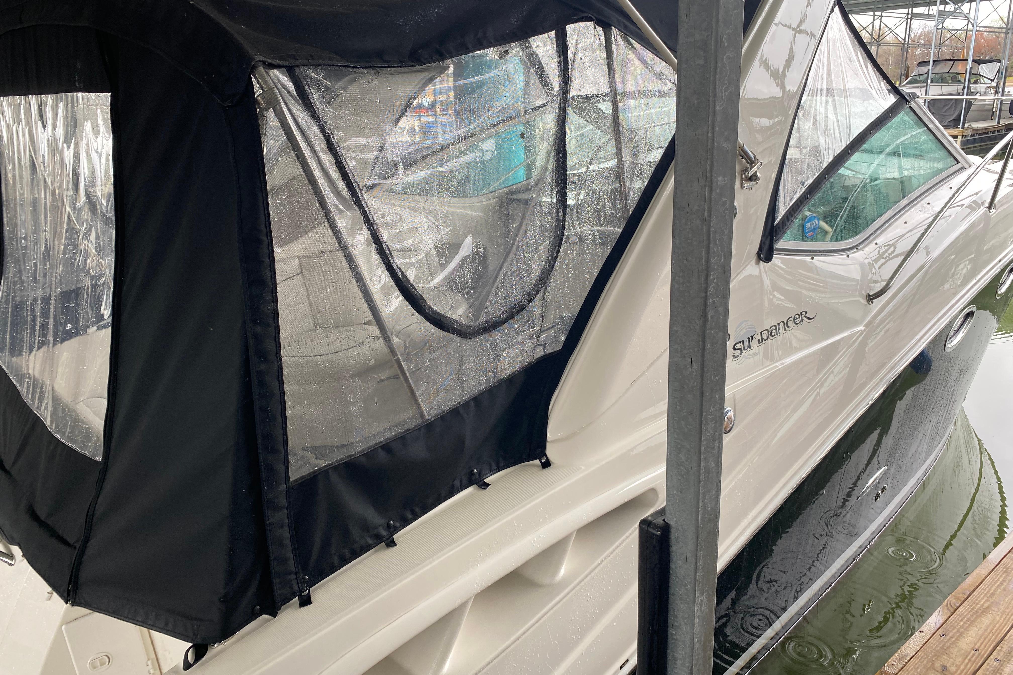 2006 Sea Ray 290 Sundancer boat with black canopy docked in marina.
