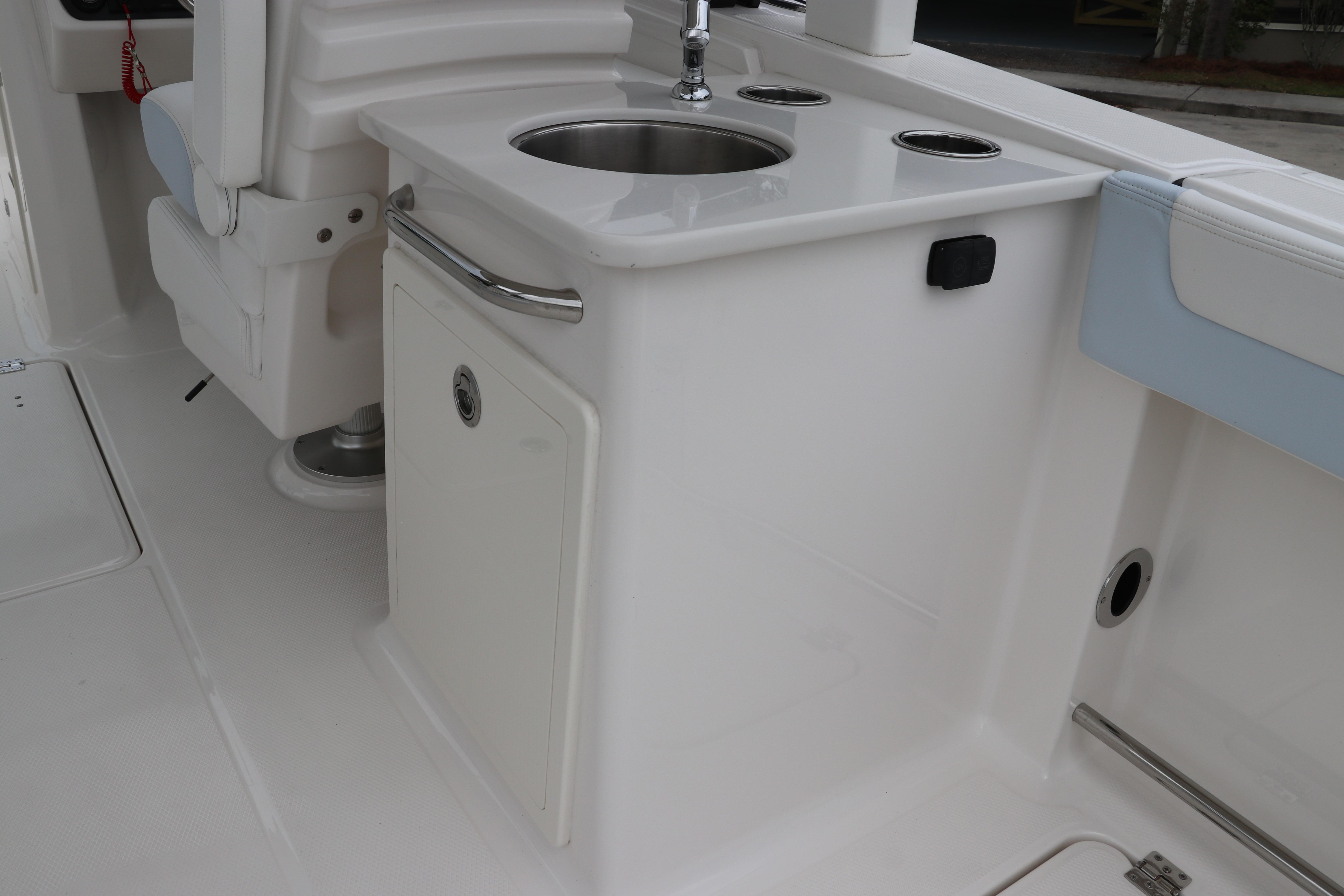 2026 Robalo R257 Dual Console boat interior with sink and seating area.
