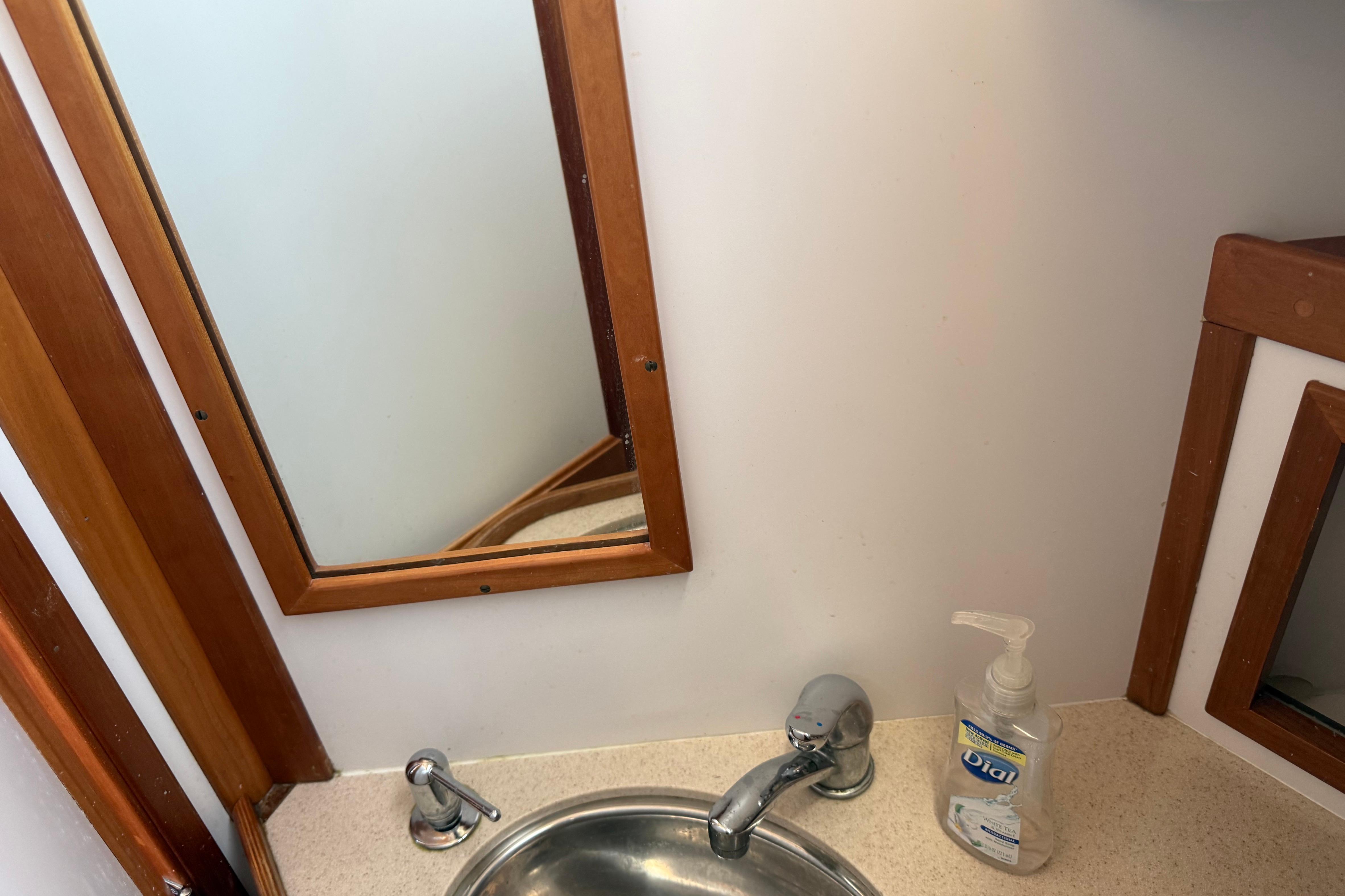 Small bathroom sink with mirror and hand soap on Sabre 386, 2004 model.