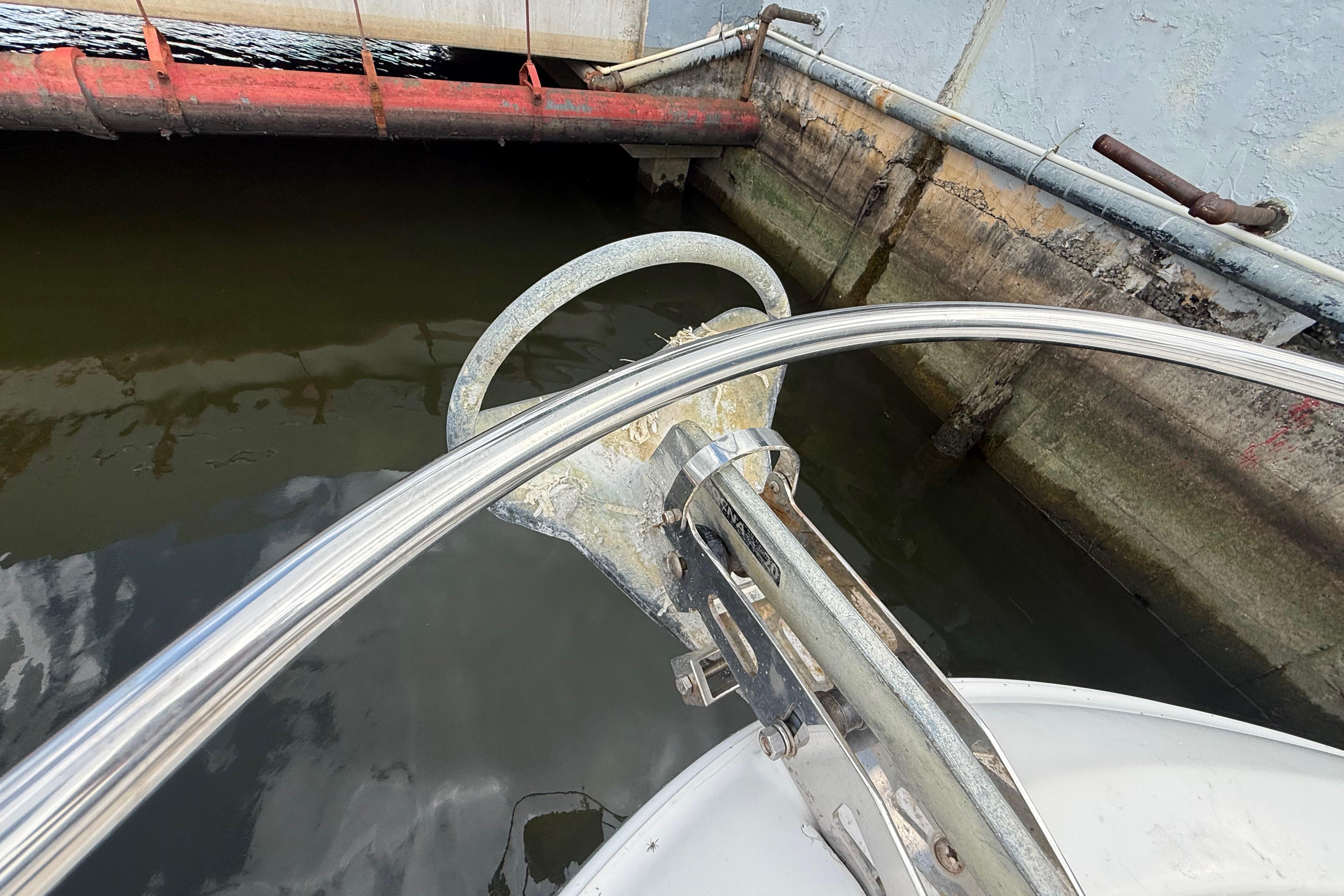 Bow anchor of 2007 Meridian 459 Motoryacht docked near concrete wall.