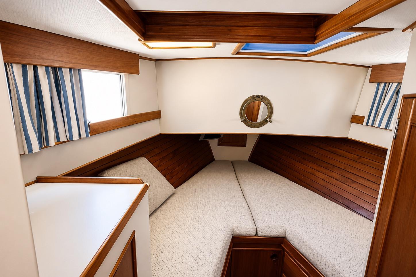 1989 Grand Banks 42 Classic cabin interior with wood paneling and striped curtains.