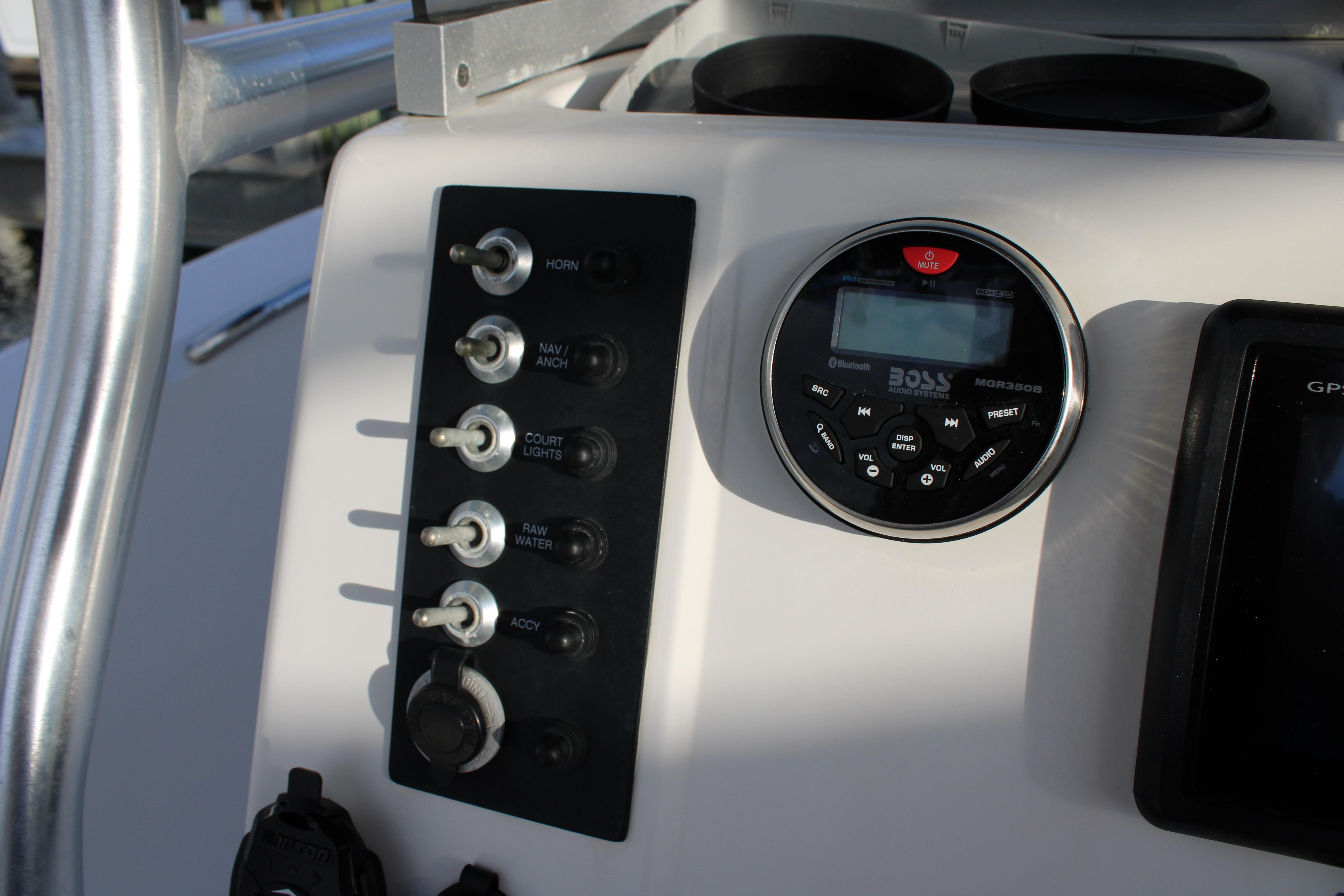Control panel of a 2017 Robalo R200 Center Console boat with switches and audio system.