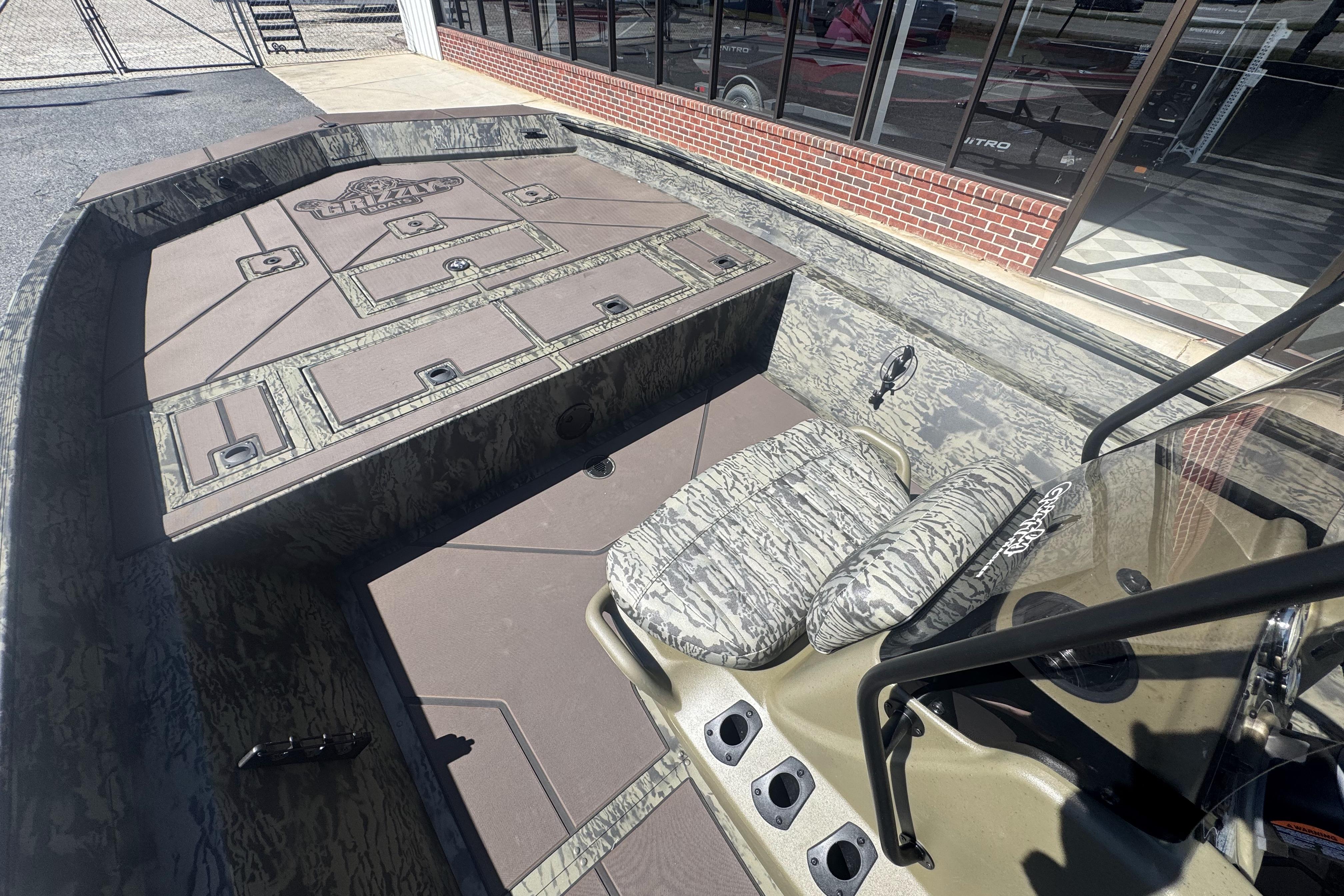 2026 Tracker Grizzly 2072 CC boat interior with camouflage seating and storage compartments.