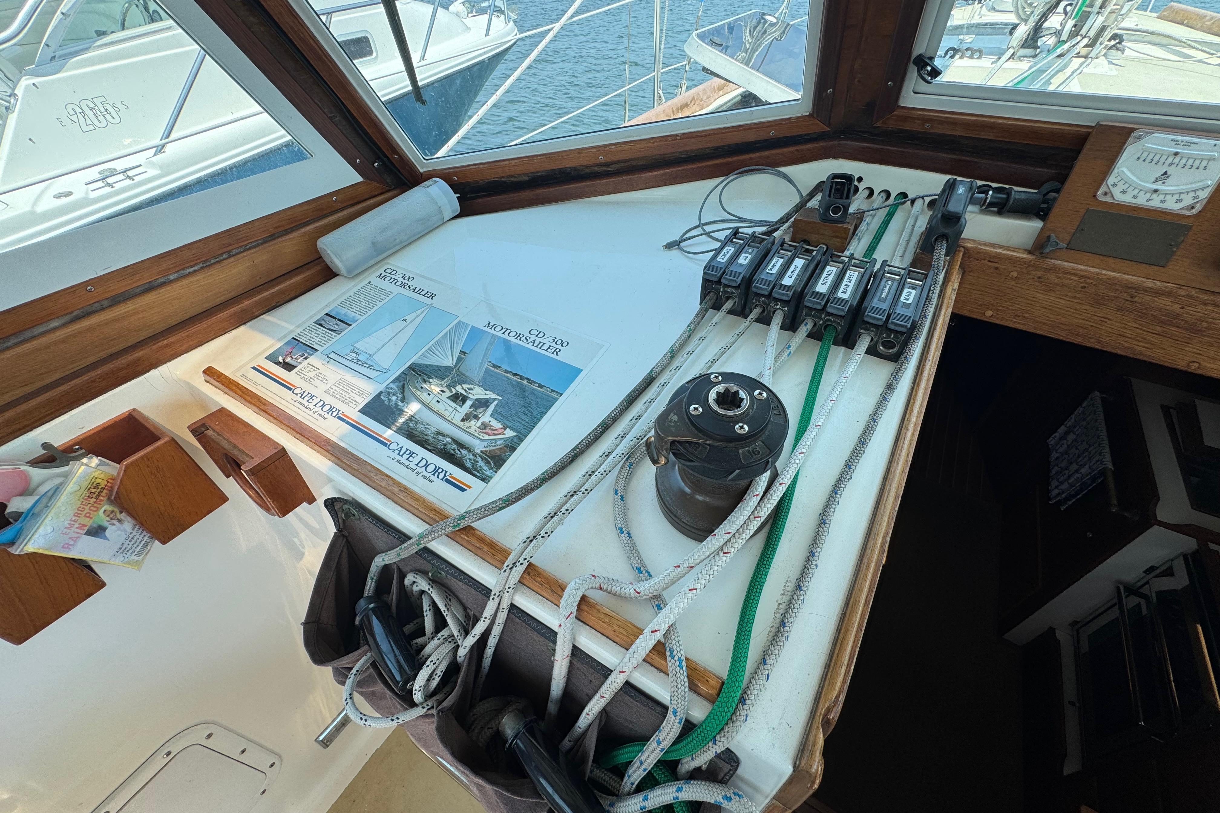 Interior view of a 1989 Cape Dory 30 Motorsailer cockpit with sailing equipment and brochures.