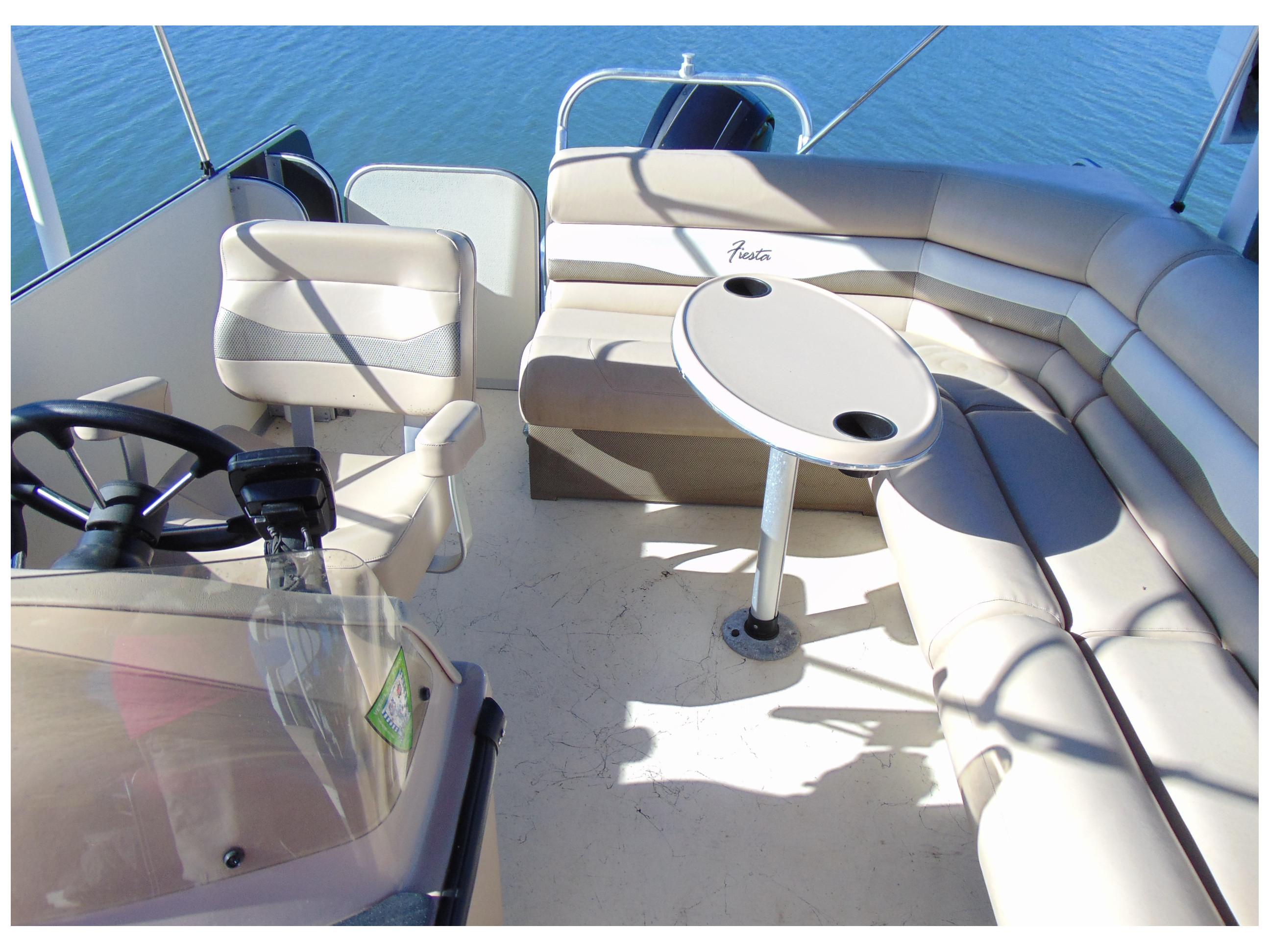 2017 Fiesta 22 Beachcomber boat interior with seating and table on calm water.