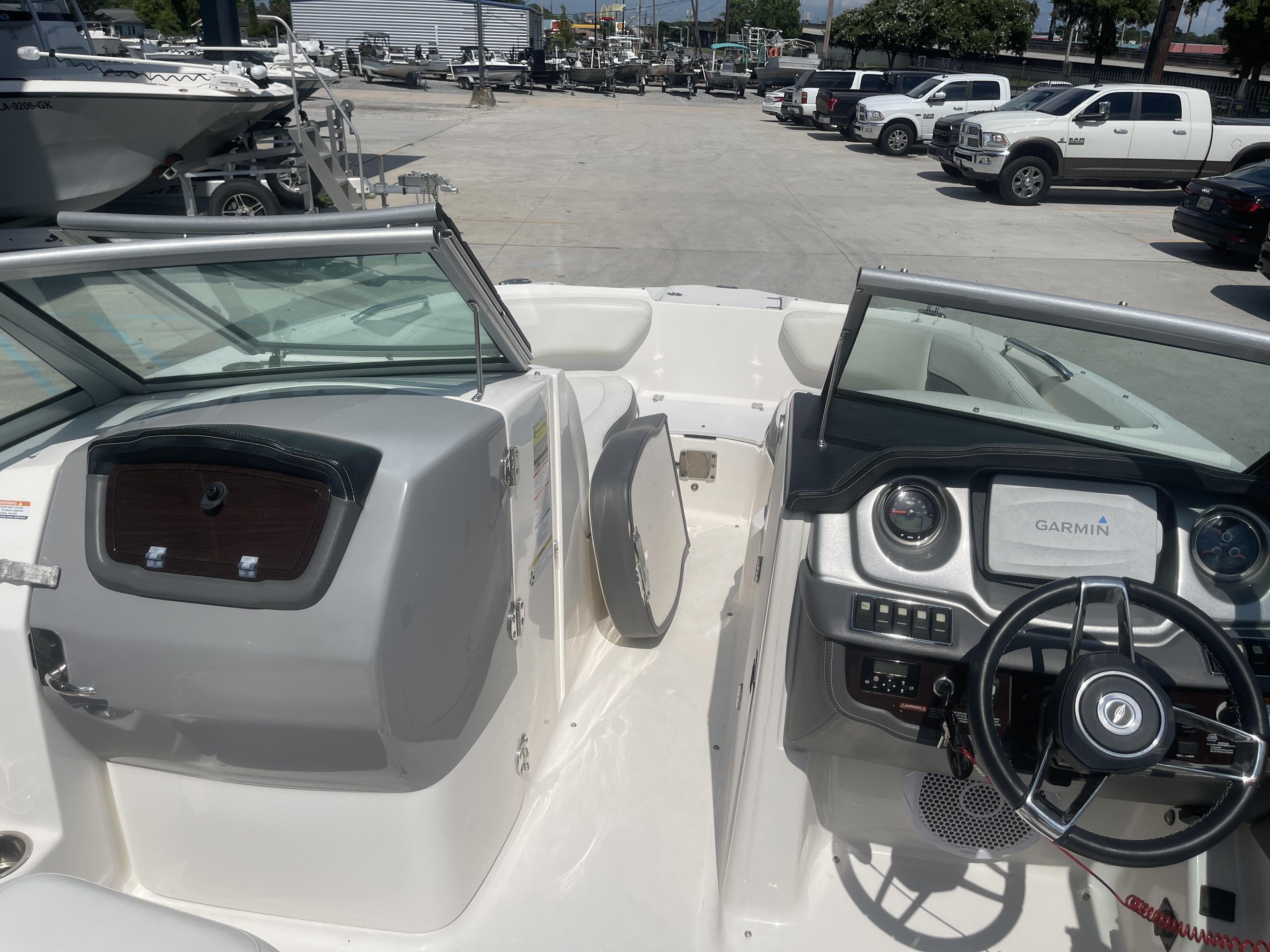 2014 Chaparral Sunesta 224 boat interior with Garmin navigation system, parked in a marina.