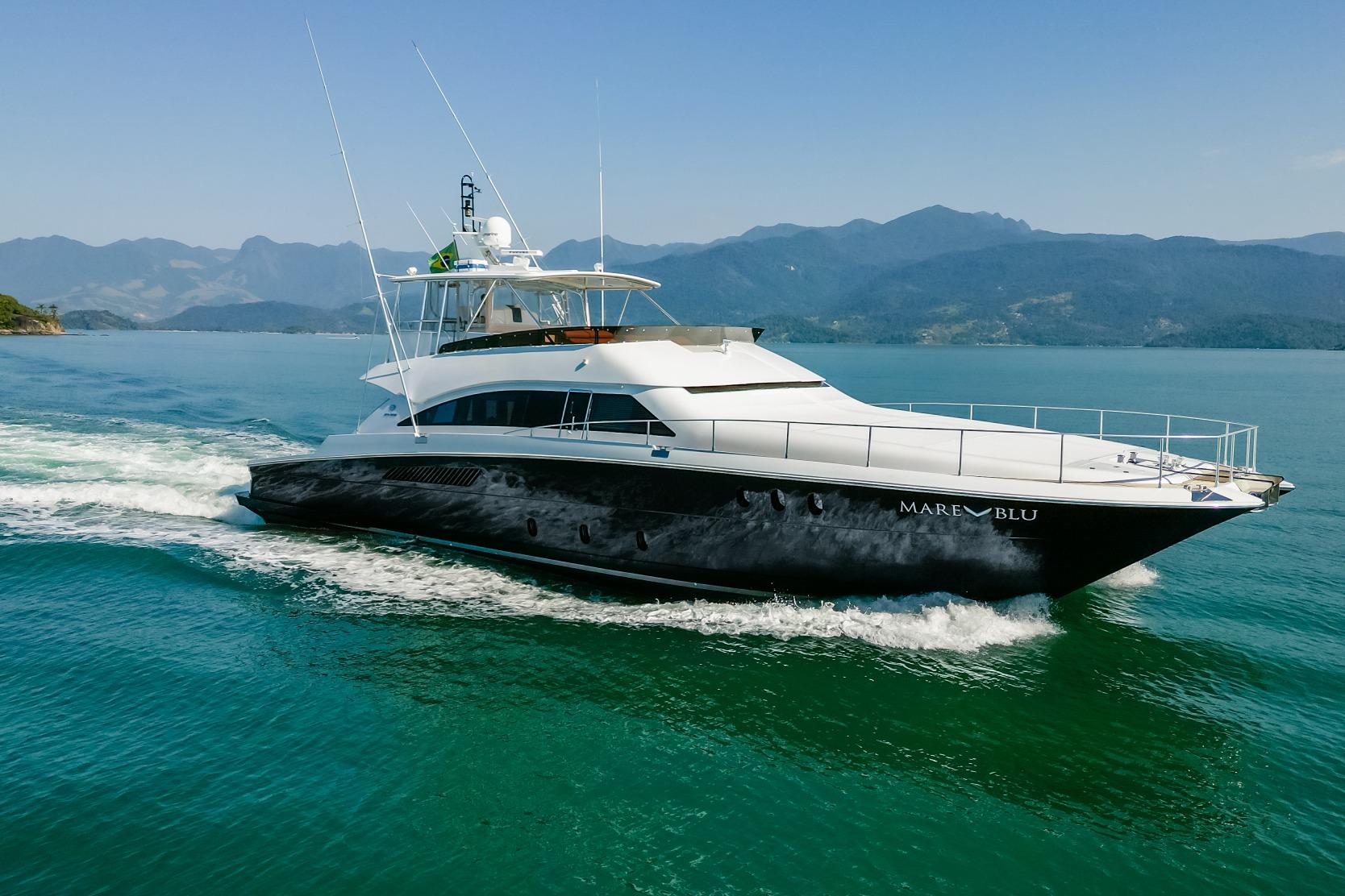 2008 Pro Boat Yachts Power Cat 80 cruising on serene waters with mountainous backdrop.