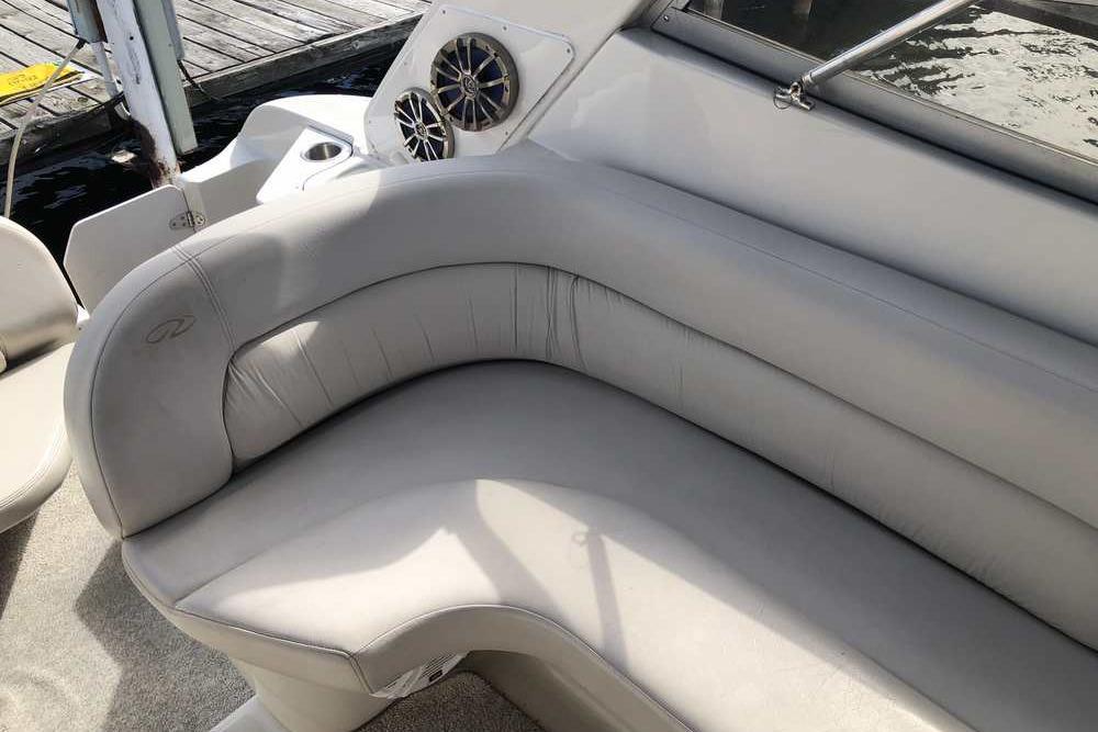 1999 Regal Commodore 2760 boat interior with gray cushioned seating and speaker system.