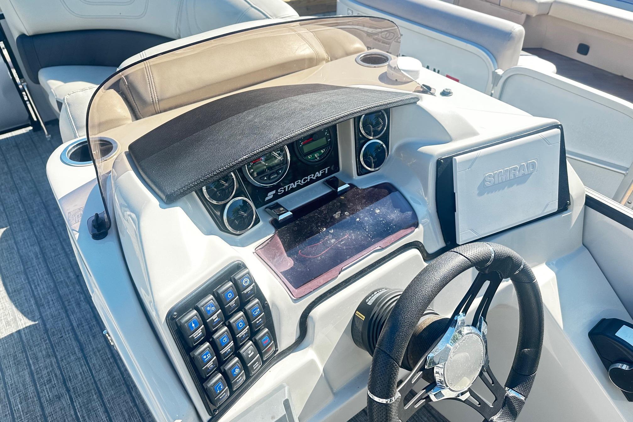 2021 Starcraft SLS 3 boat dashboard with steering wheel and Simrad display.