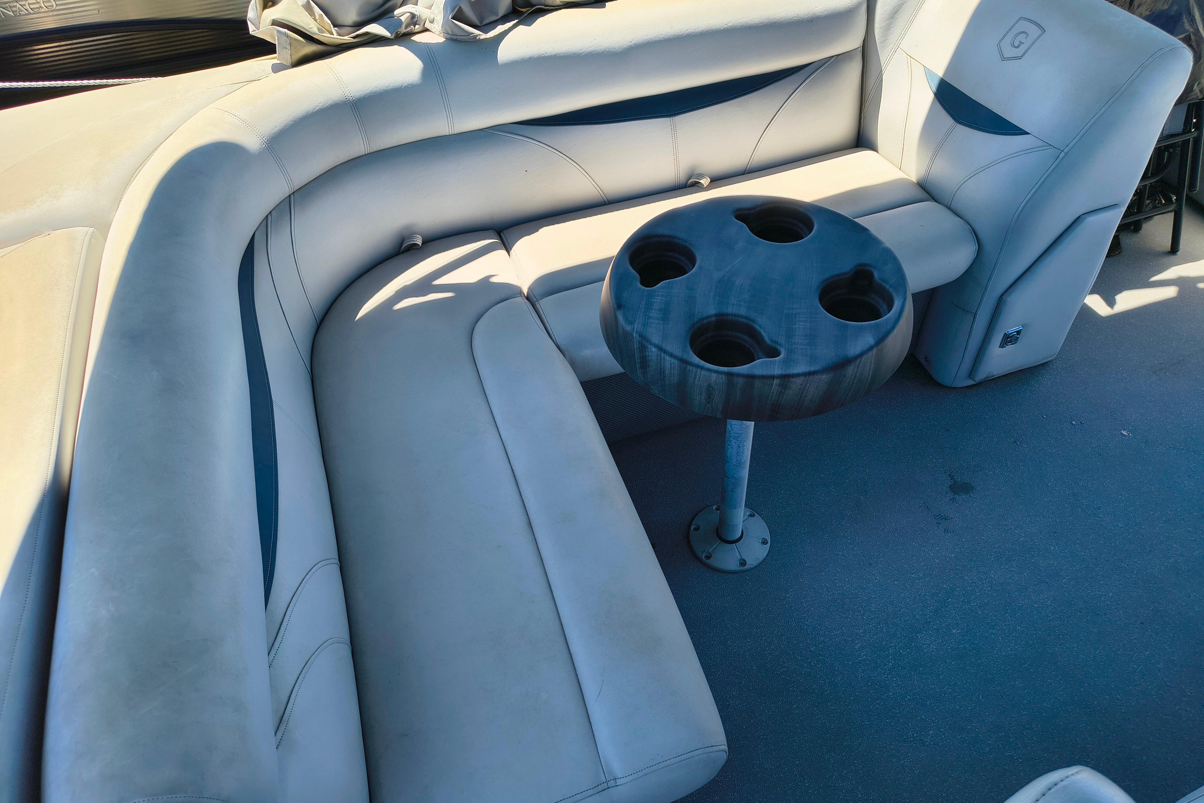 2018 Godfrey Sweetwater 2286 C boat interior with cushioned seating and cup holder table.