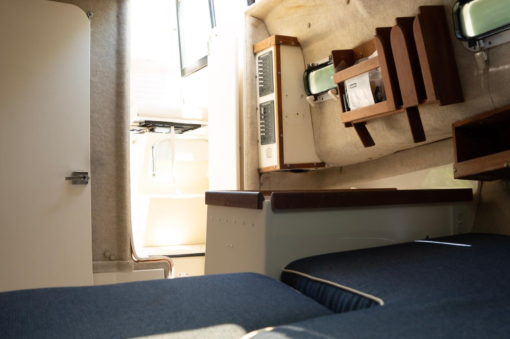 Interior of 2006 Atlas Boat Works Acadia 25, featuring cozy cabin and seating area.