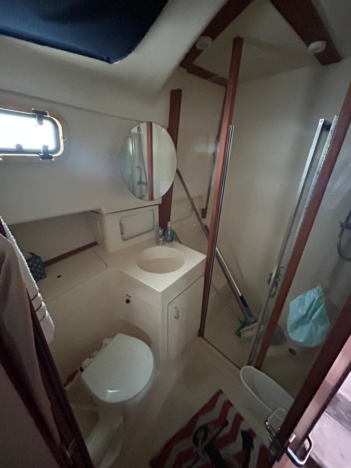 1999 Mainship 350 Trawler bathroom with shower, sink, and toilet.