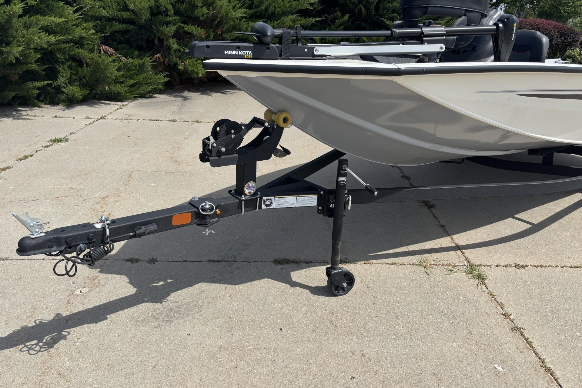 2024 Tracker Pro Team 175 TF boat on trailer, parked on concrete surface.