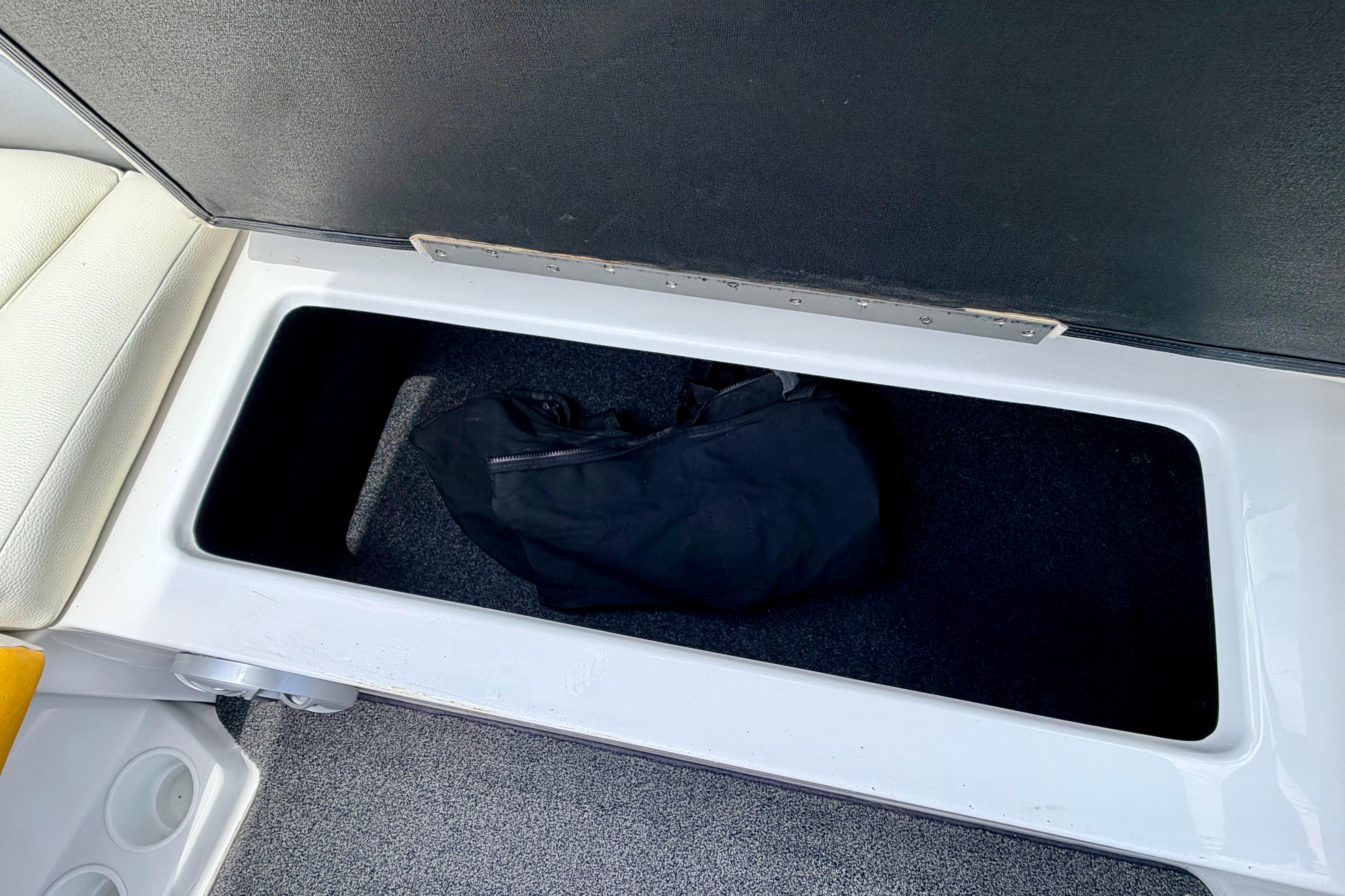 Storage compartment in 2014 Tigé R20 boat with black bag inside.
