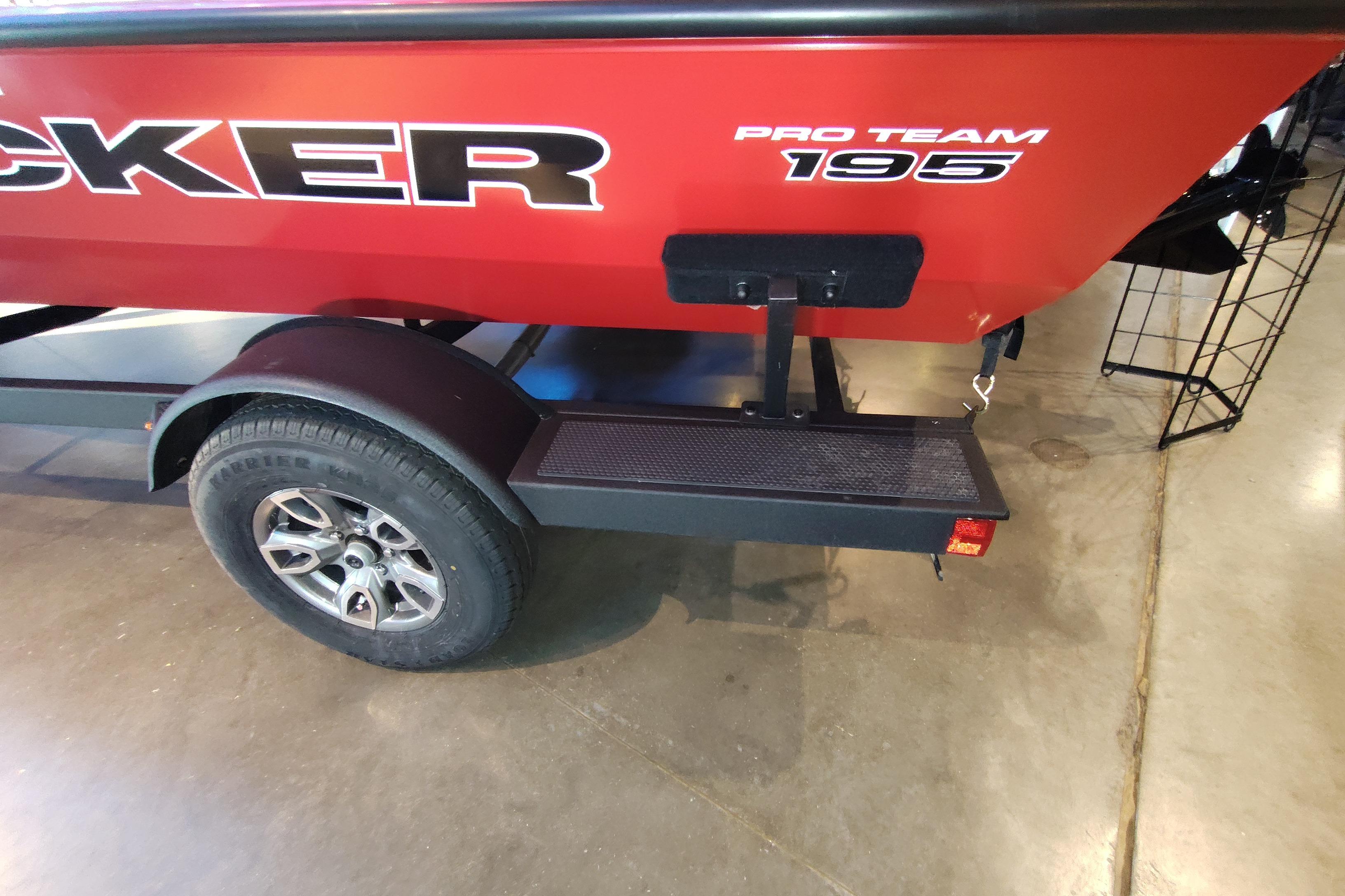 Red 2026 Tracker Pro Team 195 boat on trailer, showcasing rear design and wheel.