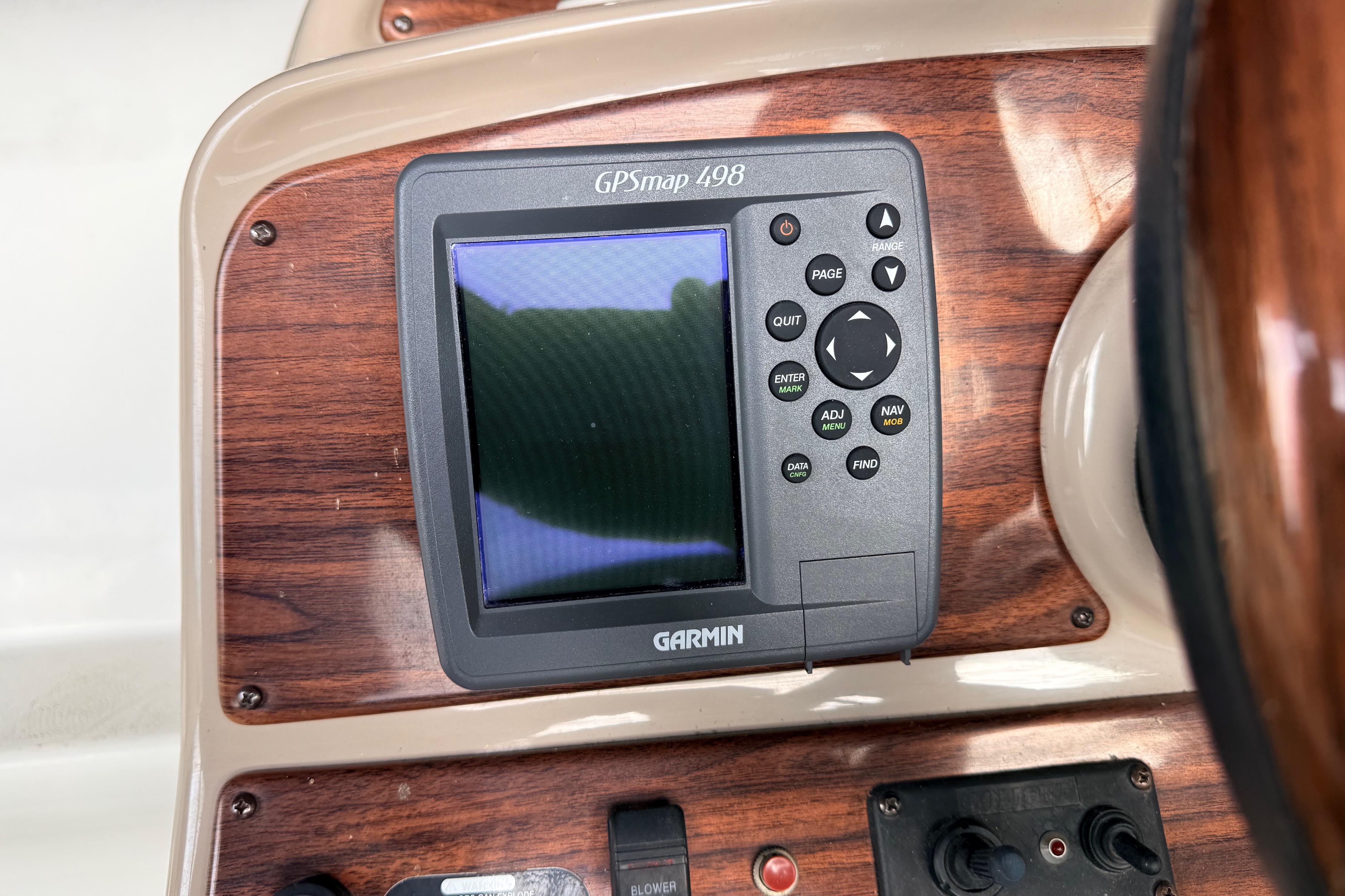 Garmin GPSmap 498 on 2007 Glastron GS 279 boat dashboard with wood paneling.