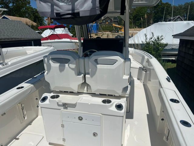 The image shows the cockpit of a 2023 Pursuit S268 boat with two seats and storage.