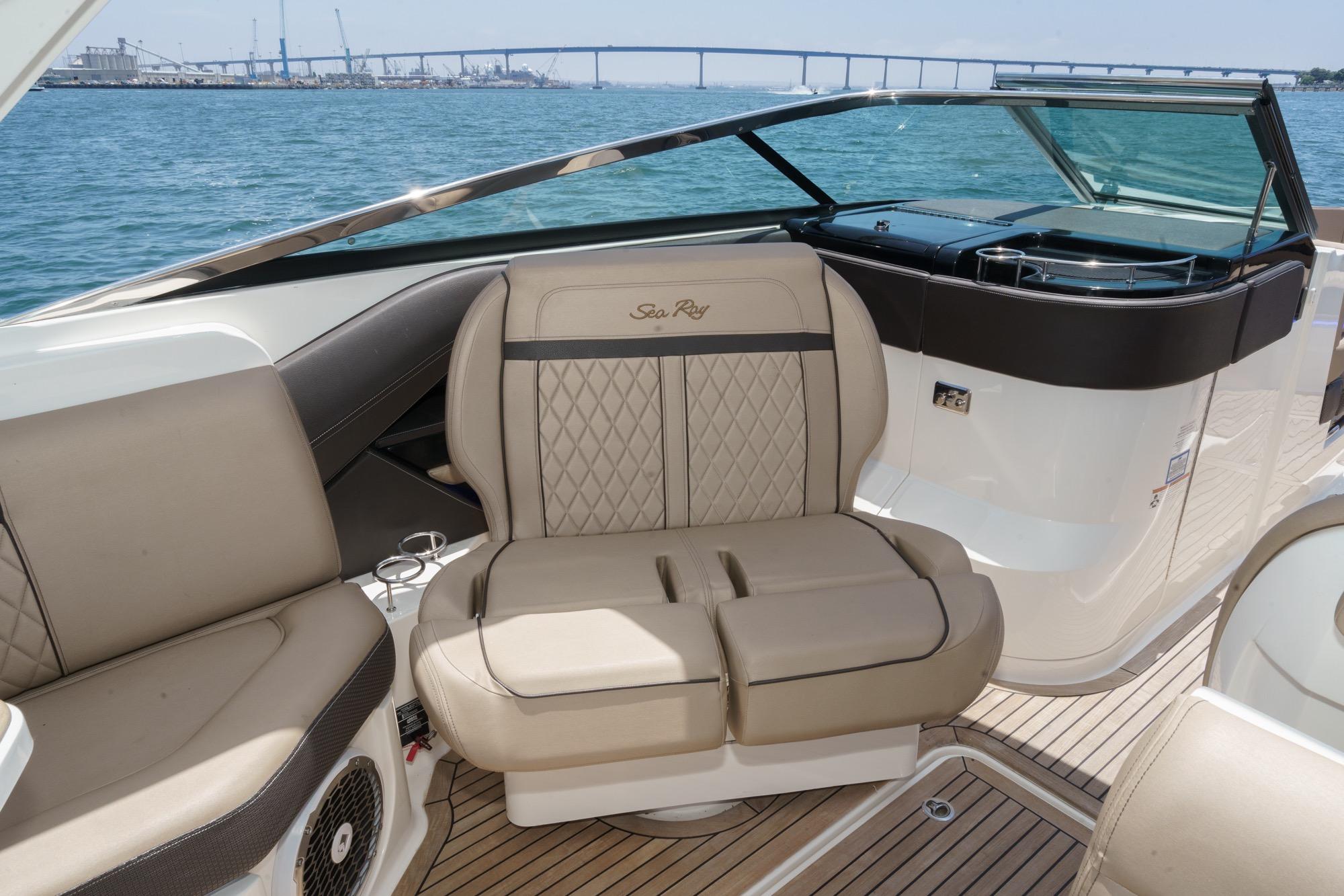 Luxurious interior of 2018 Sea Ray SLX 310 boat with beige seating and ocean view.