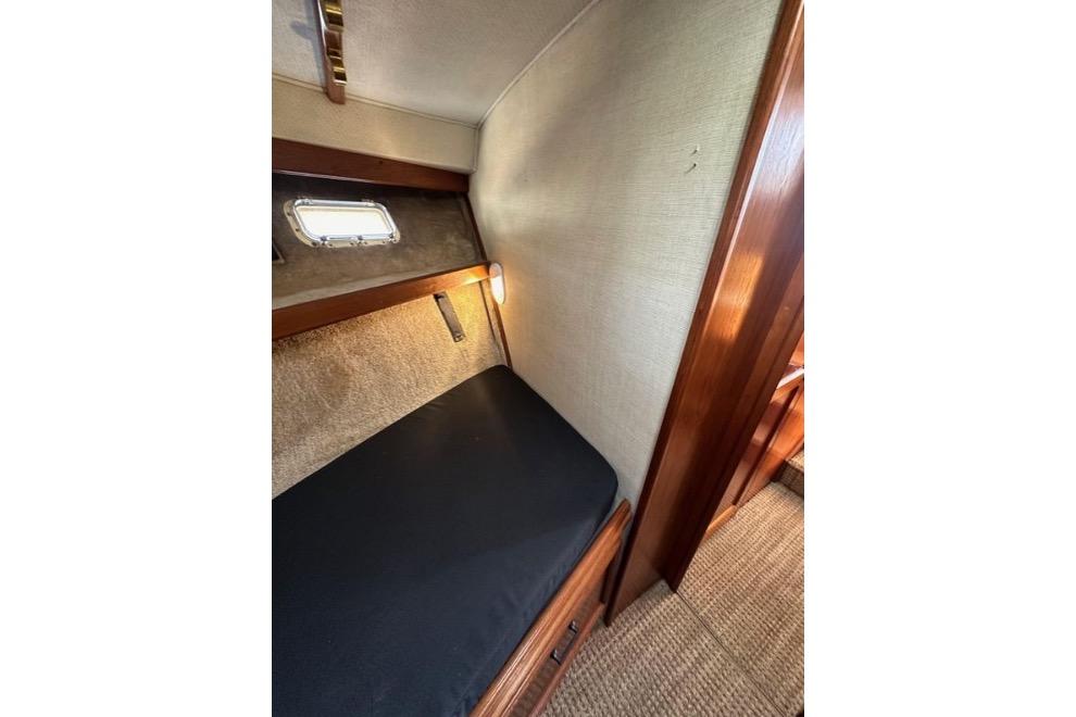 1985 Egg Harbor 33 Sedan cabin interior with cozy bed and porthole window.