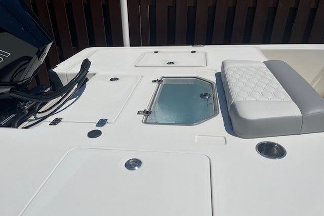 2026 Mako 18 Pro Skiff boat deck with storage compartments and seating.