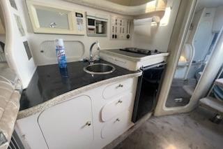 2000 Rinker Fiesta Vee 310 boat interior with kitchenette and modern amenities.