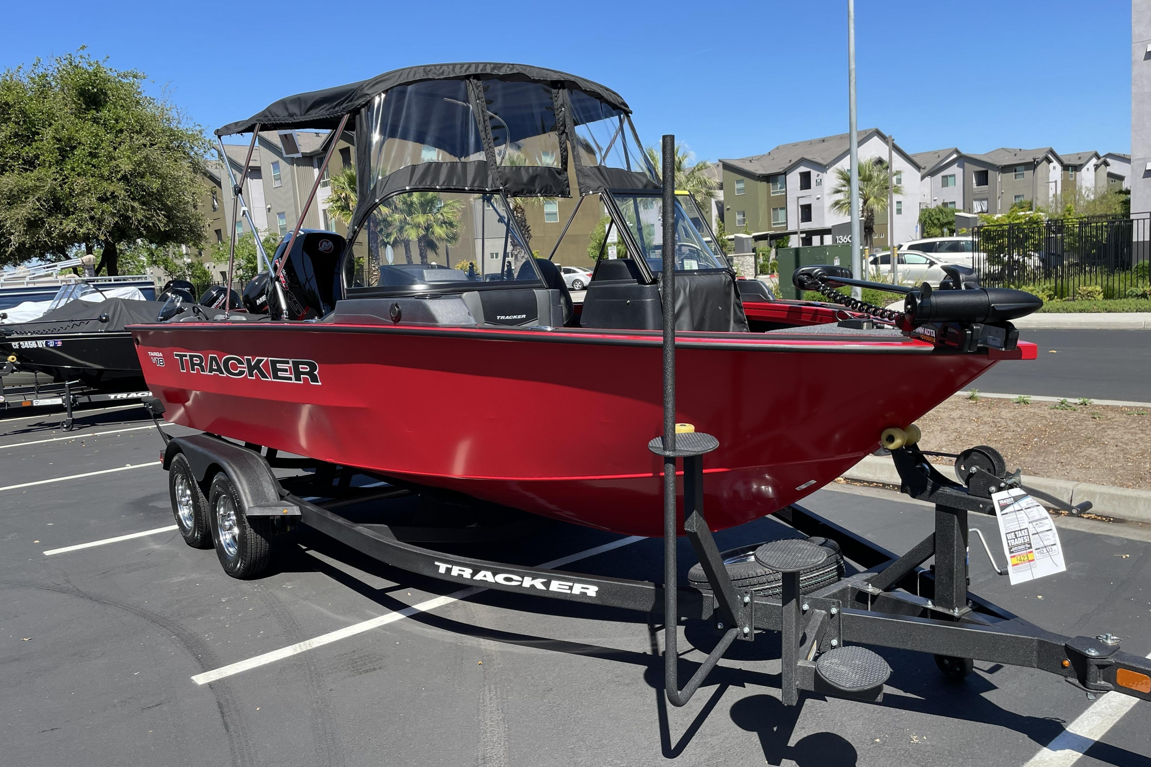 2026 Tracker Targa V-18 WT boat in vibrant red on a trailer, parked outdoors.