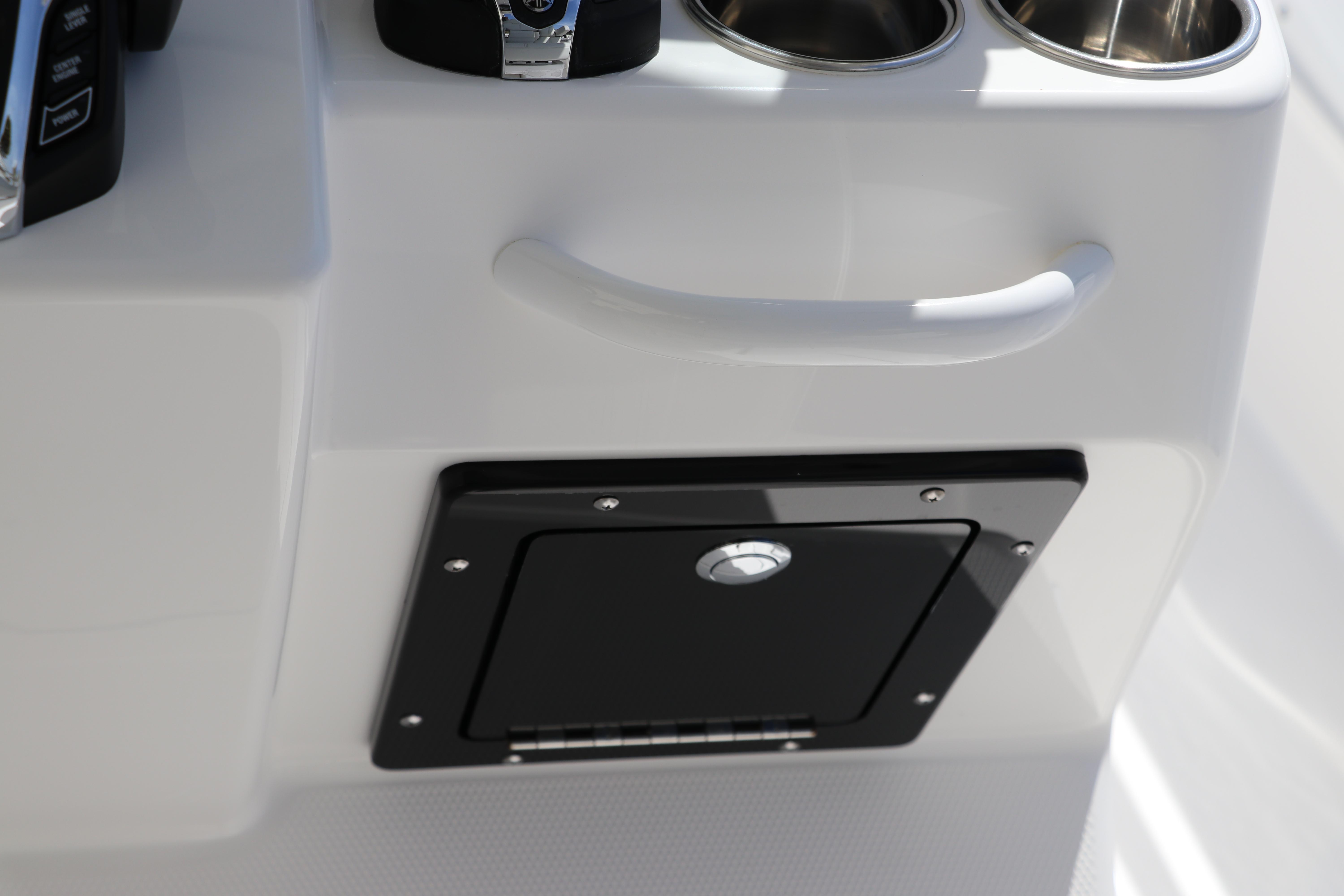 Edgewater 325CC 2025 boat console with storage compartment and cup holders.