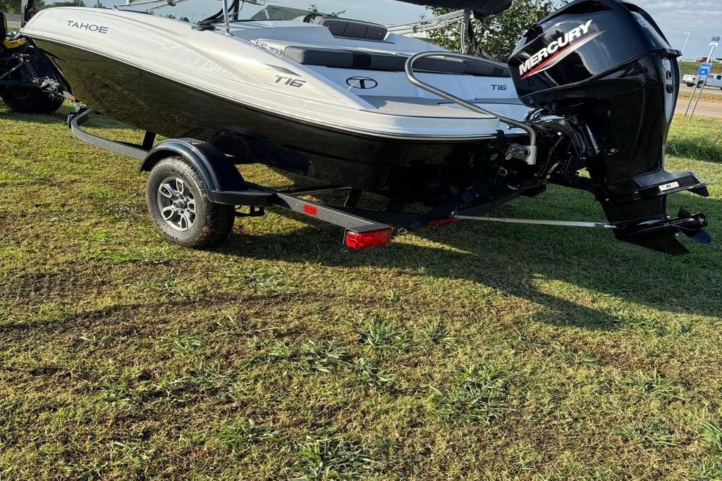 2026 Tahoe T16 boat with Mercury engine on trailer, parked on grass.