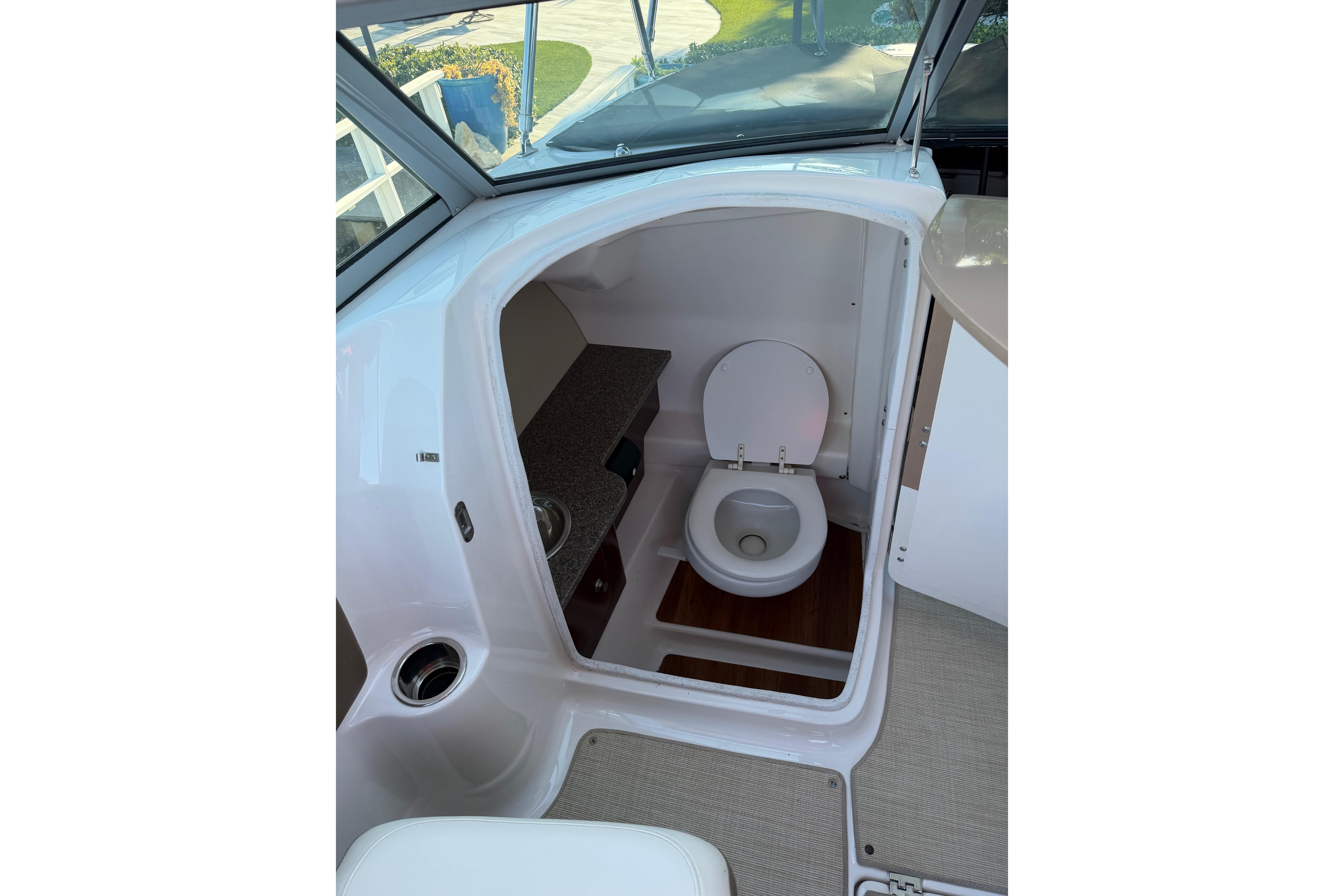 2015 Chaparrall 264 Sunesta boat interior with compact toilet and sink.