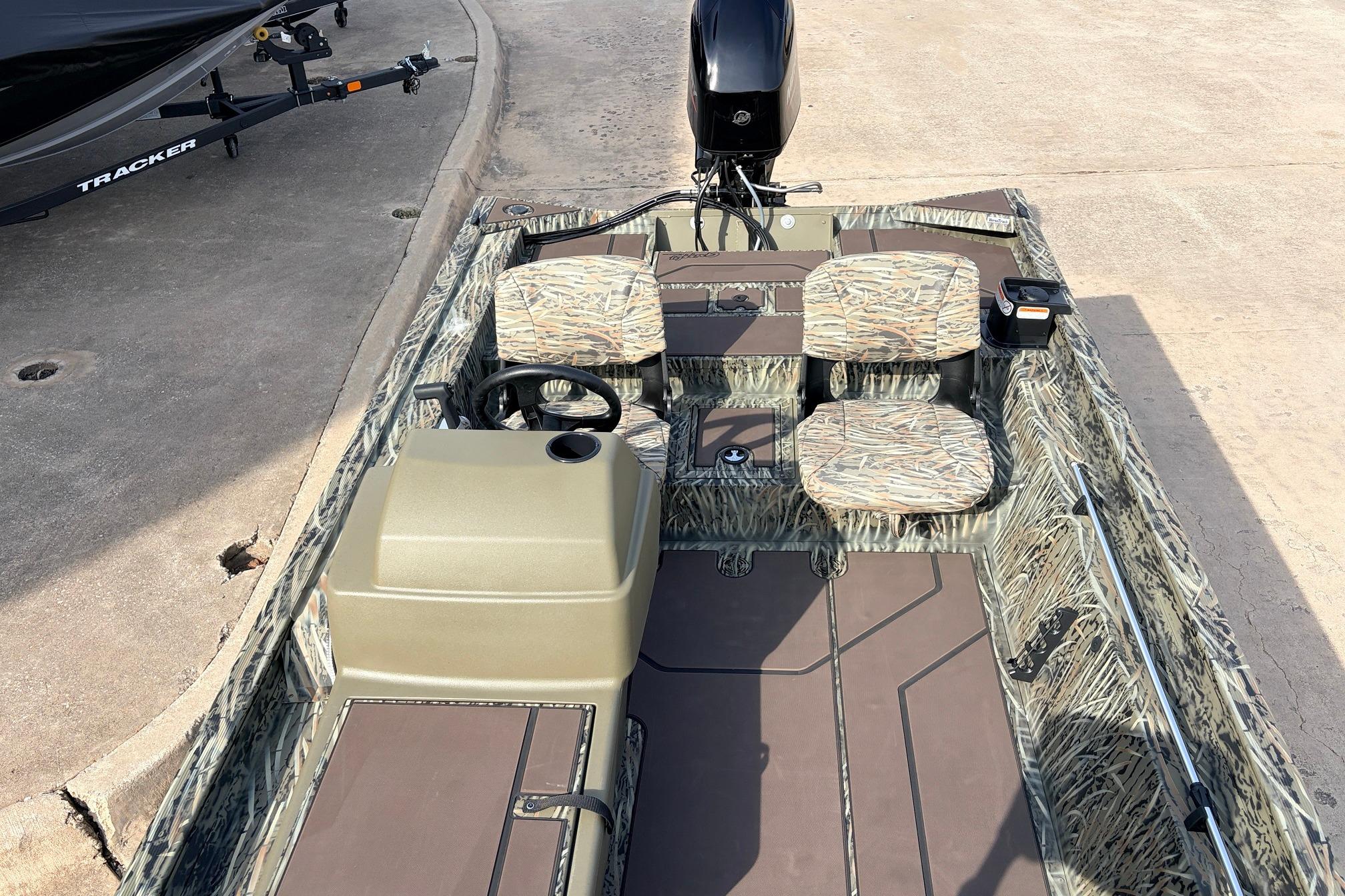 2026 Tracker Grizzly 1754 SC boat with camouflage seating and steering console.