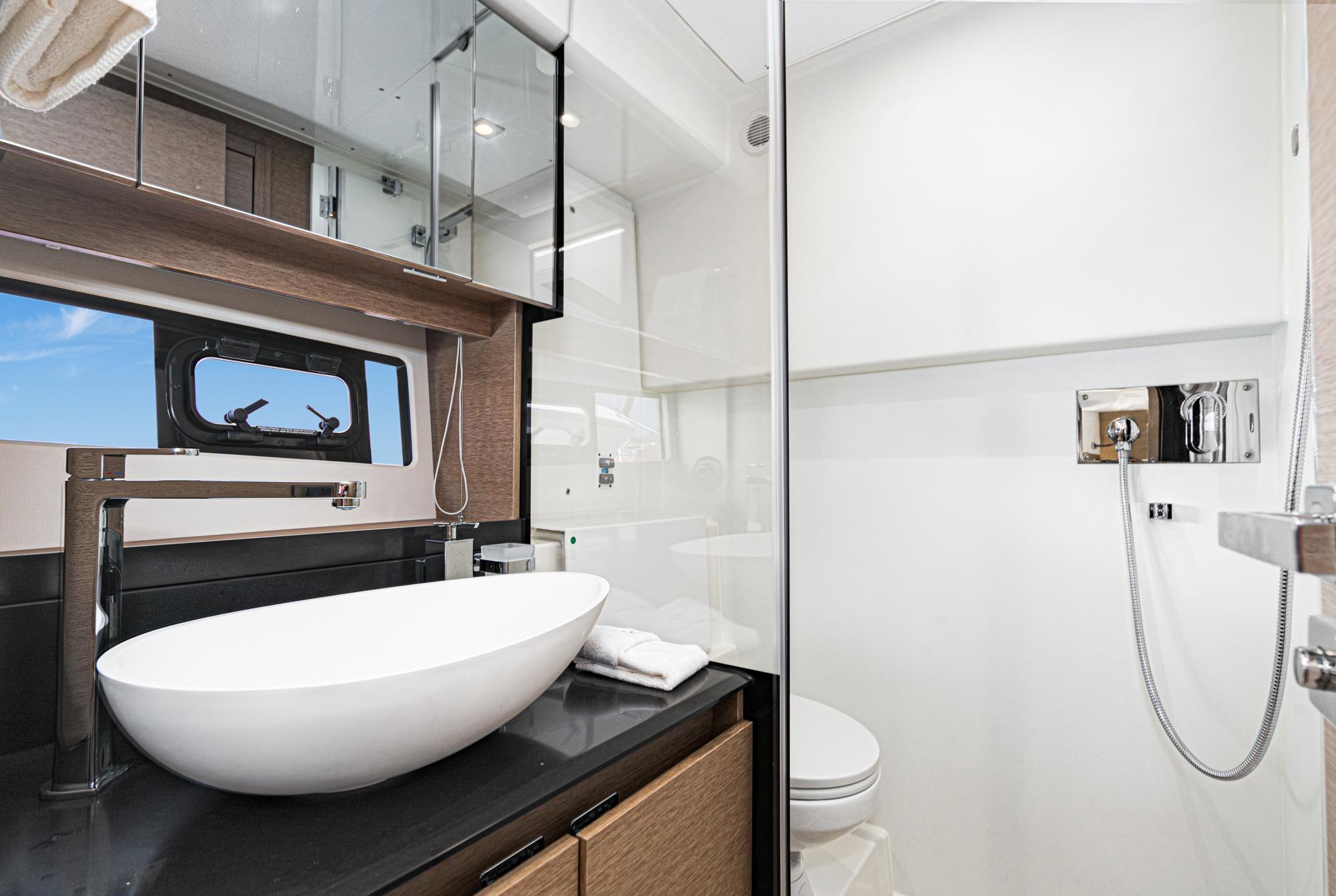 Modern bathroom in 2022 Prestige 460 yacht with sleek fixtures and large mirror.
