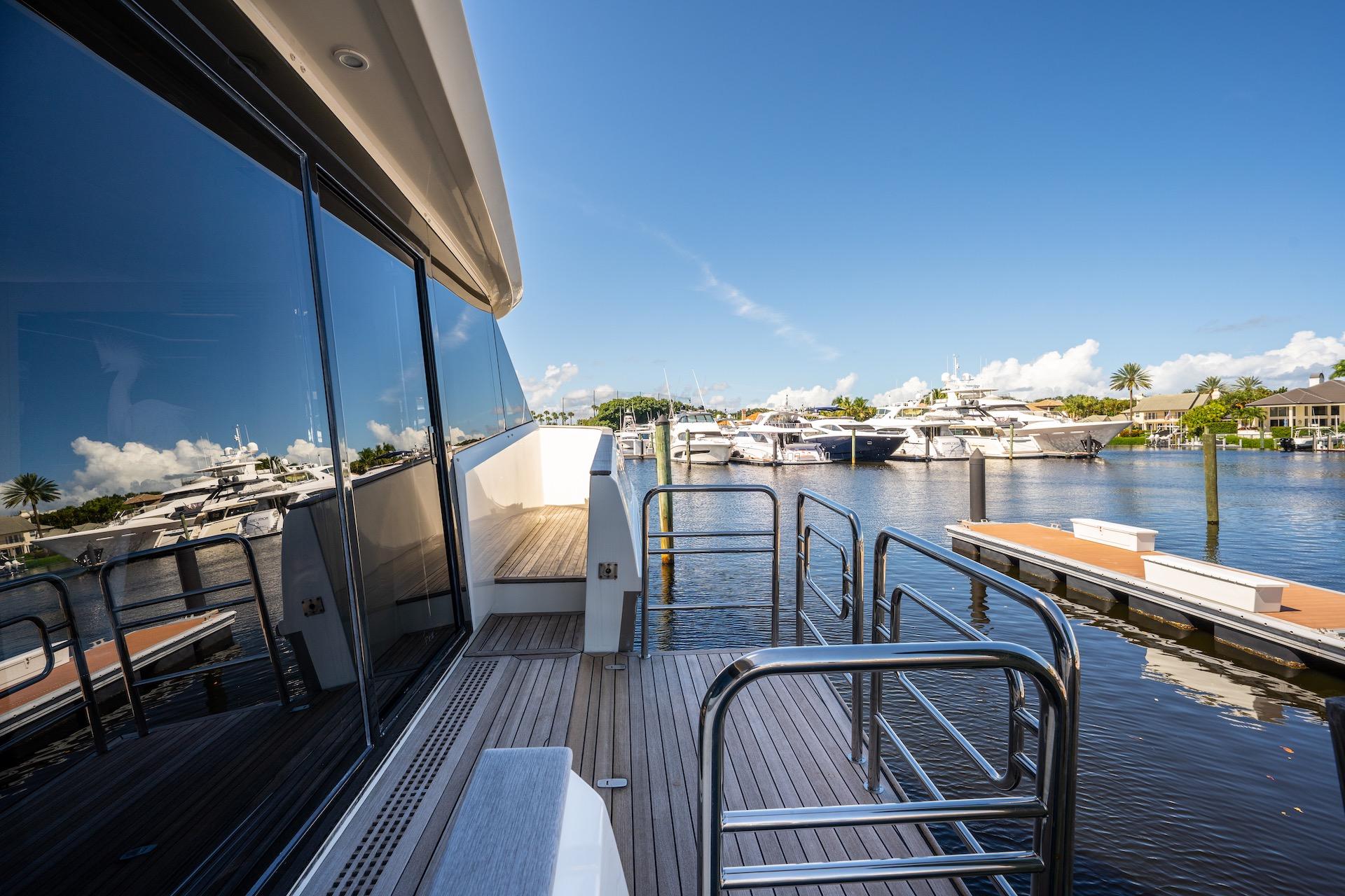 2015 Monte Carlo Yachts MCY 86 docked, reflecting on calm marina waters.