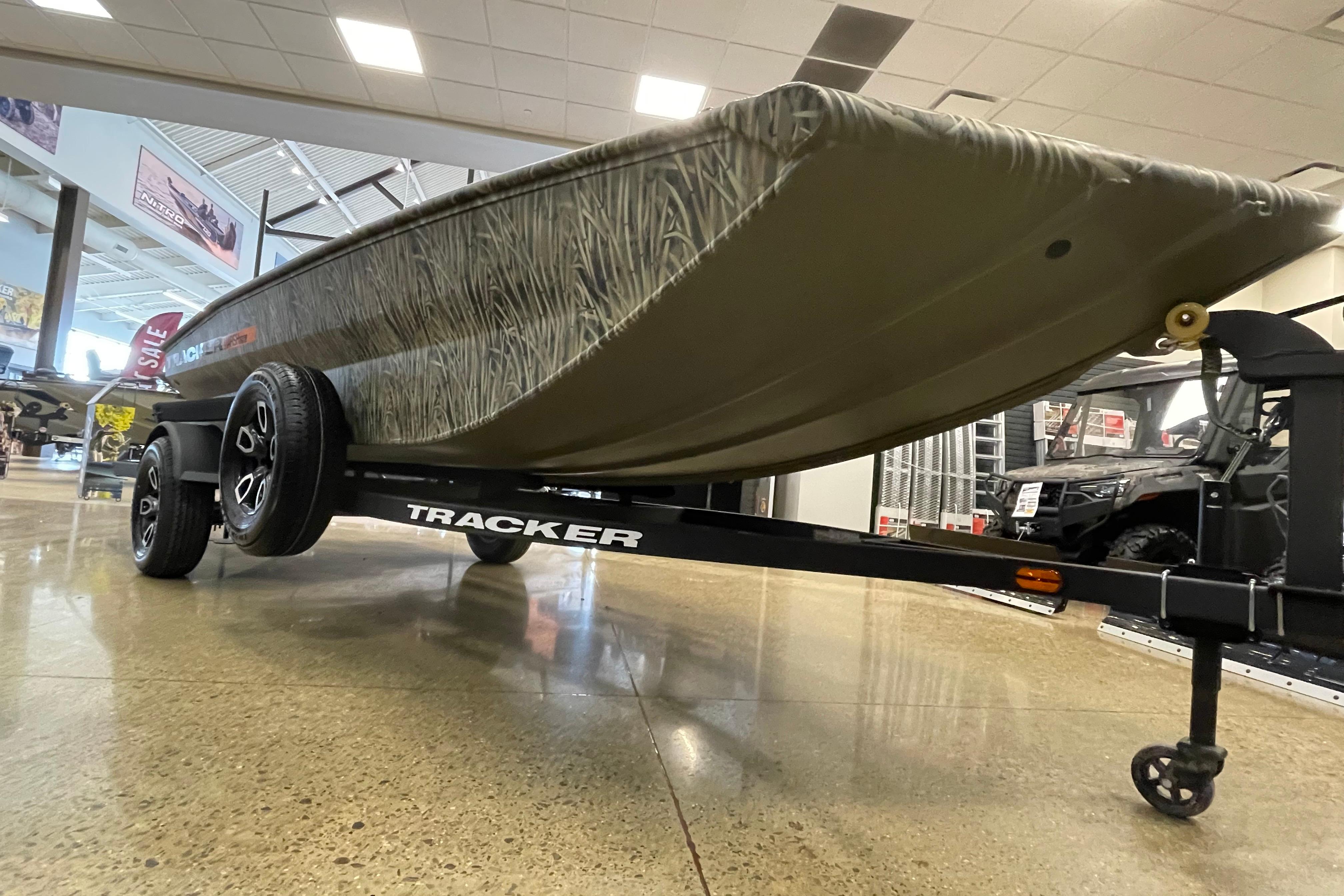 2026 Tracker Grizzly 1756 T Marsh boat on display in showroom, mounted on trailer.