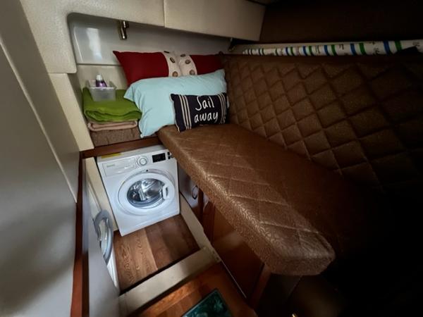 Compact cabin interior of a 2009 Ovation 52 yacht with washer and cozy bed.